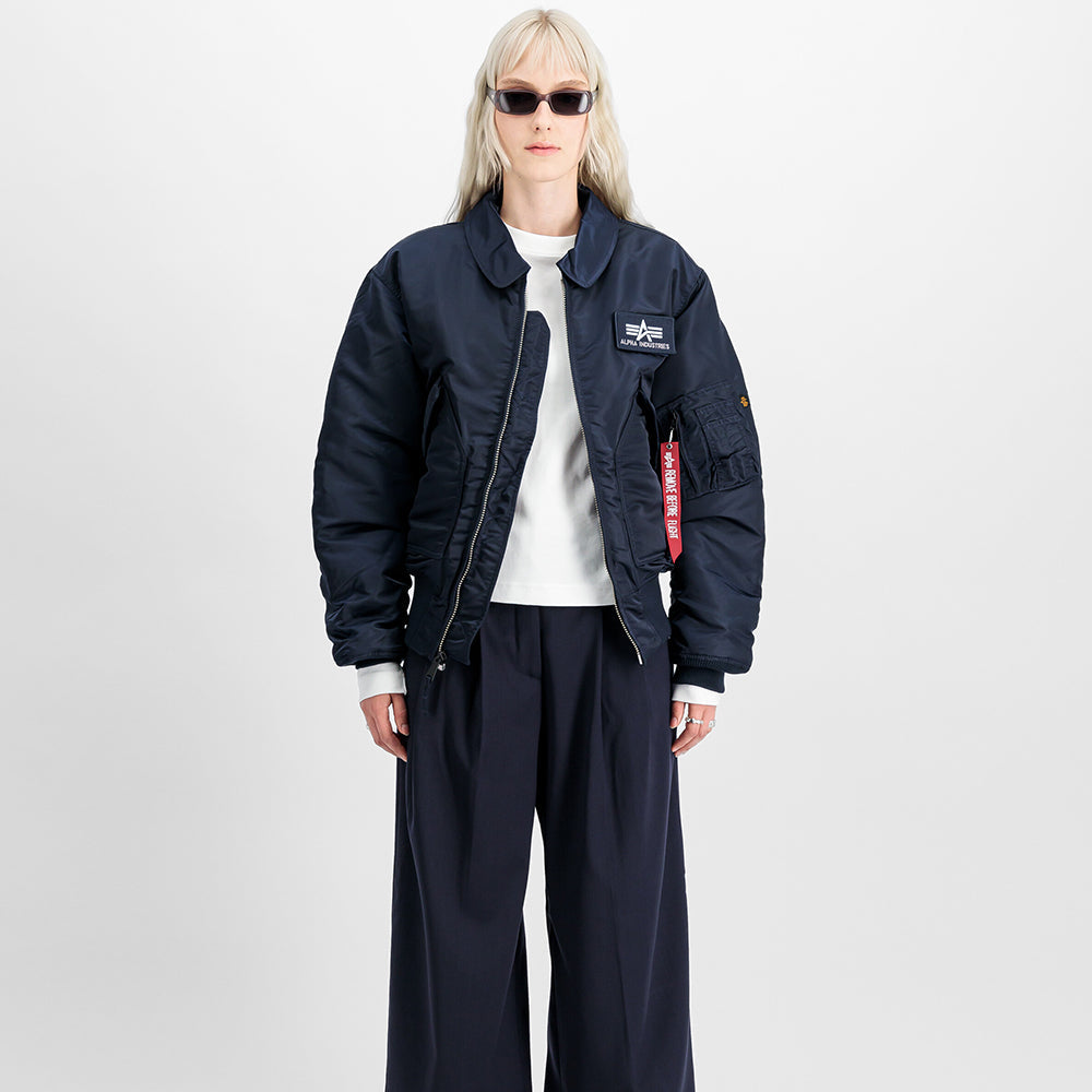 "Alpha Industries CWU 45 Heritage Bomberjacke in Rep. Blue, aus robustem Nylon, mit Rippbündchen, Utility-Tasche am Ärmel und gestepptem Innenfutter."