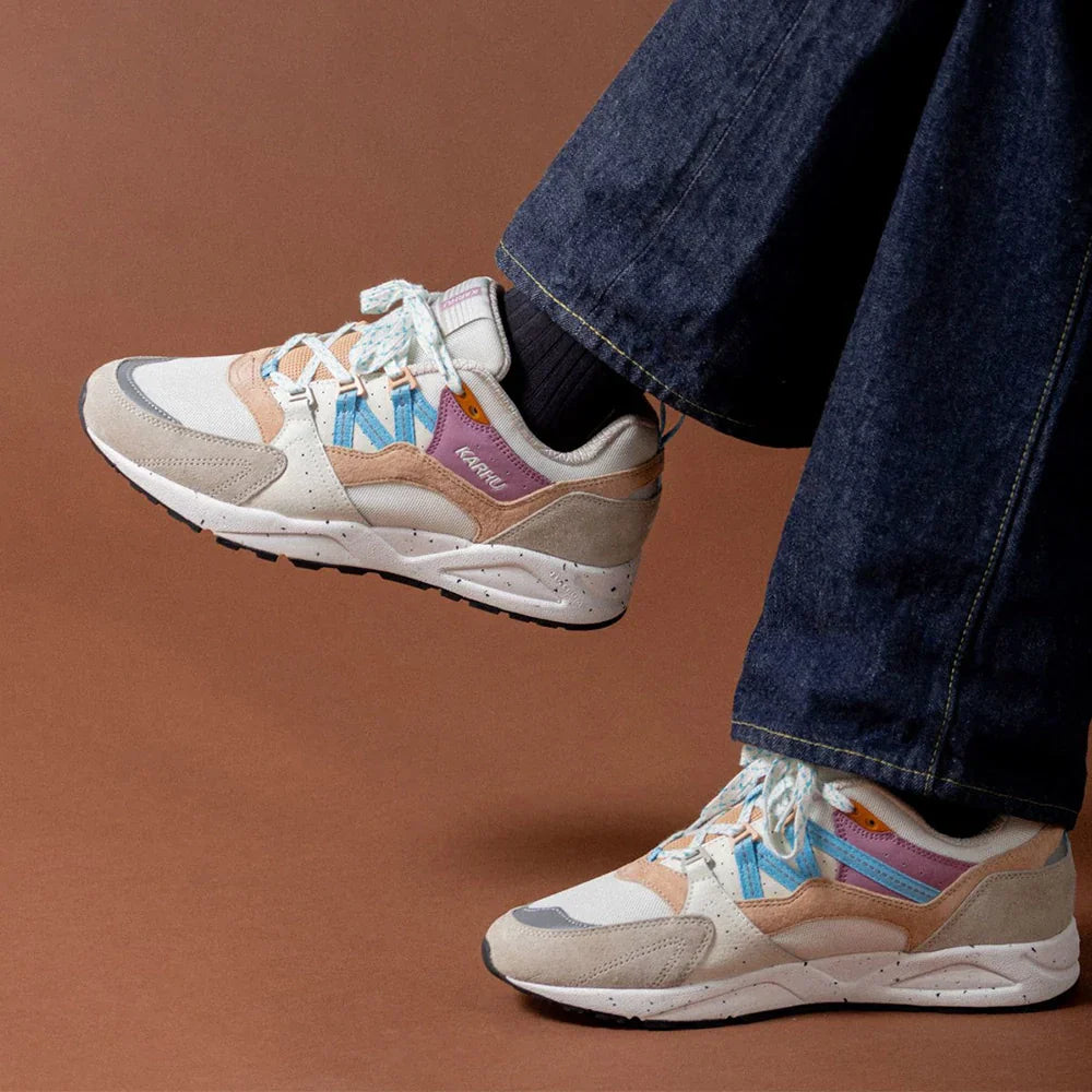 "Karhu Fusion 2.0 Sneaker in Silbergrau mit Akzenten in Blau und Pink, aus Wildleder und Mesh, von der Seite abgebildet.“