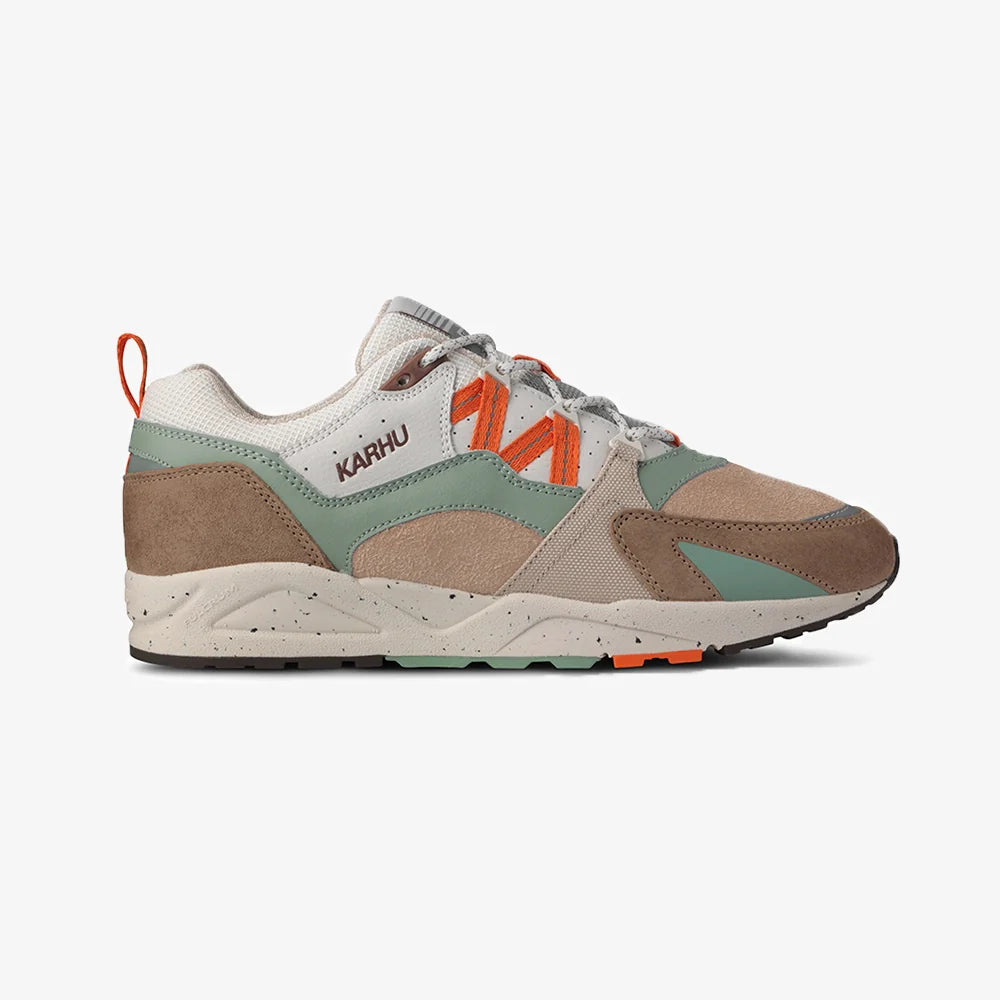"Wildleder-Sneaker in warmen Braun- und Orangetönen mit beigem Mesh und dem Karhu 'M'-Logo.“