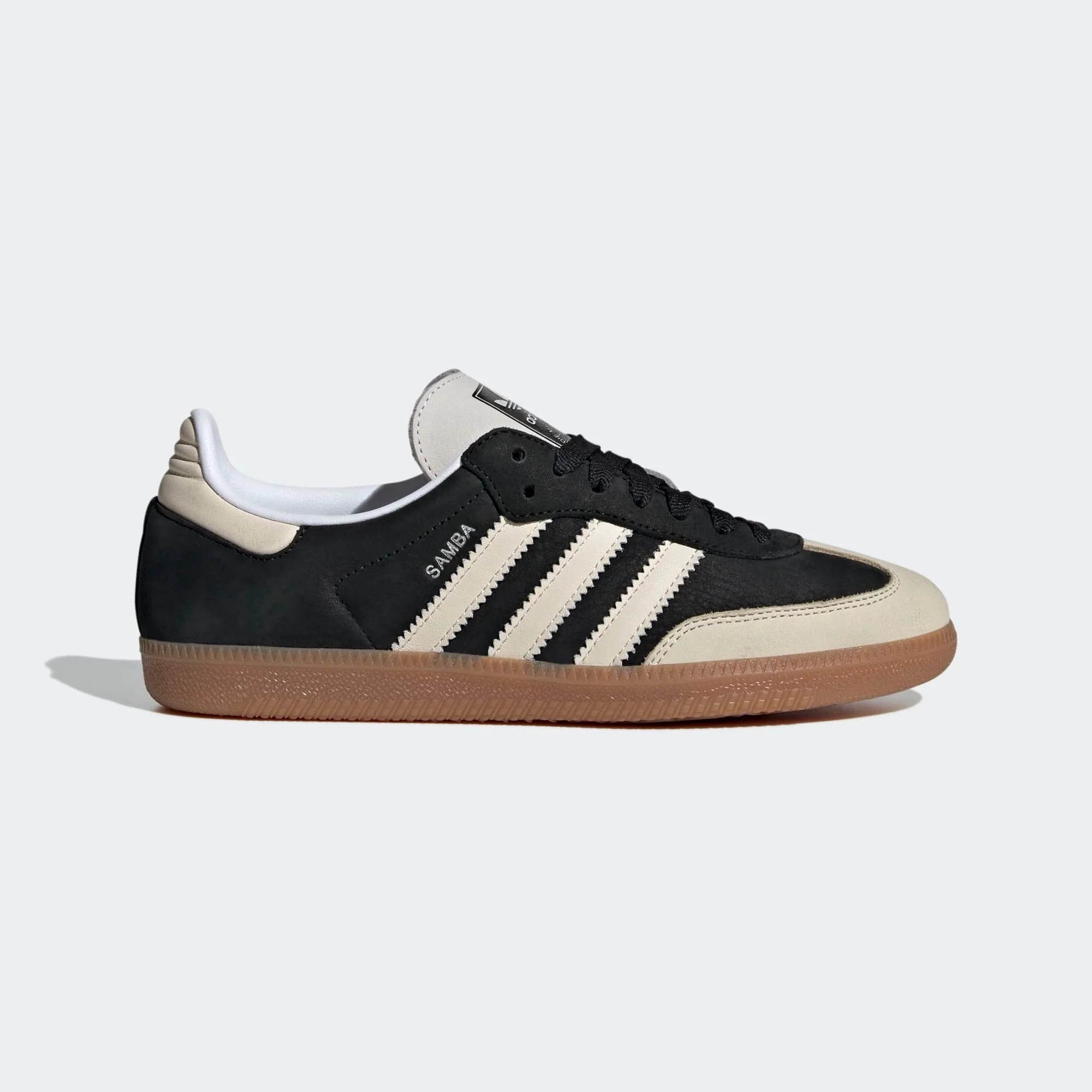 Adidas Samba OG Sneaker in Schwarz. Gefertigt aus Leder und Wildleder, mit beigefarbenem 3-Streifen und silberfarbenem Samba-Schriftzug.