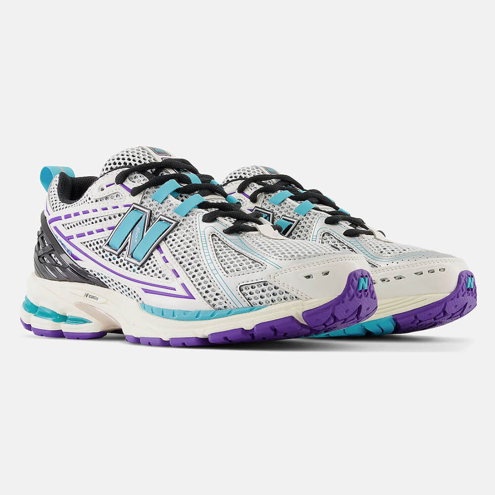 New Balance 1906R CF. Cremefarbener Sneaker mit lila und türkisen Akzenten. Obermaterial aus Mesh und Synthetik-Overlays mit goldener Fersenspange und ABZORB-Sohle.