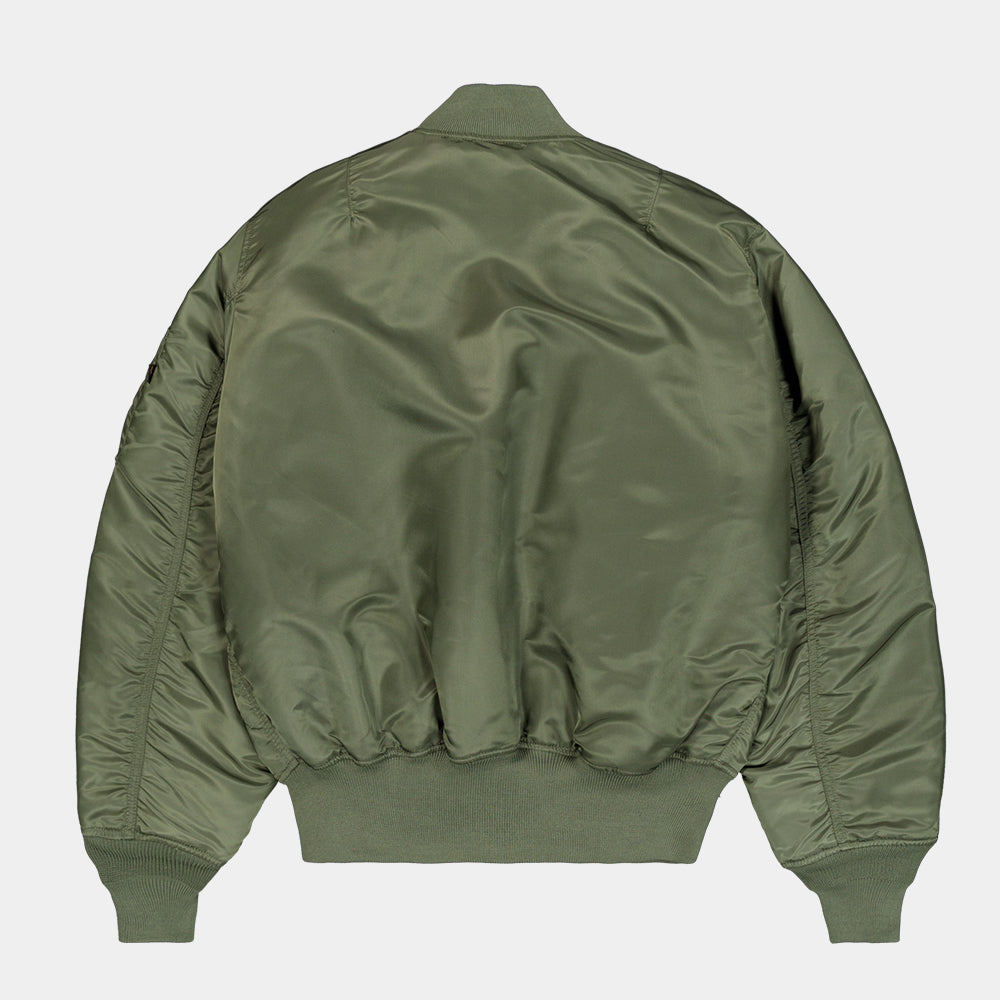 “Alpha Industries MA-1 (HERITAGE) Bomberjacke in Sage Green, aus robustem Nylon, mit orangefarbenem Innenfutter und ikonischem Ärmeltaschen-Design.“