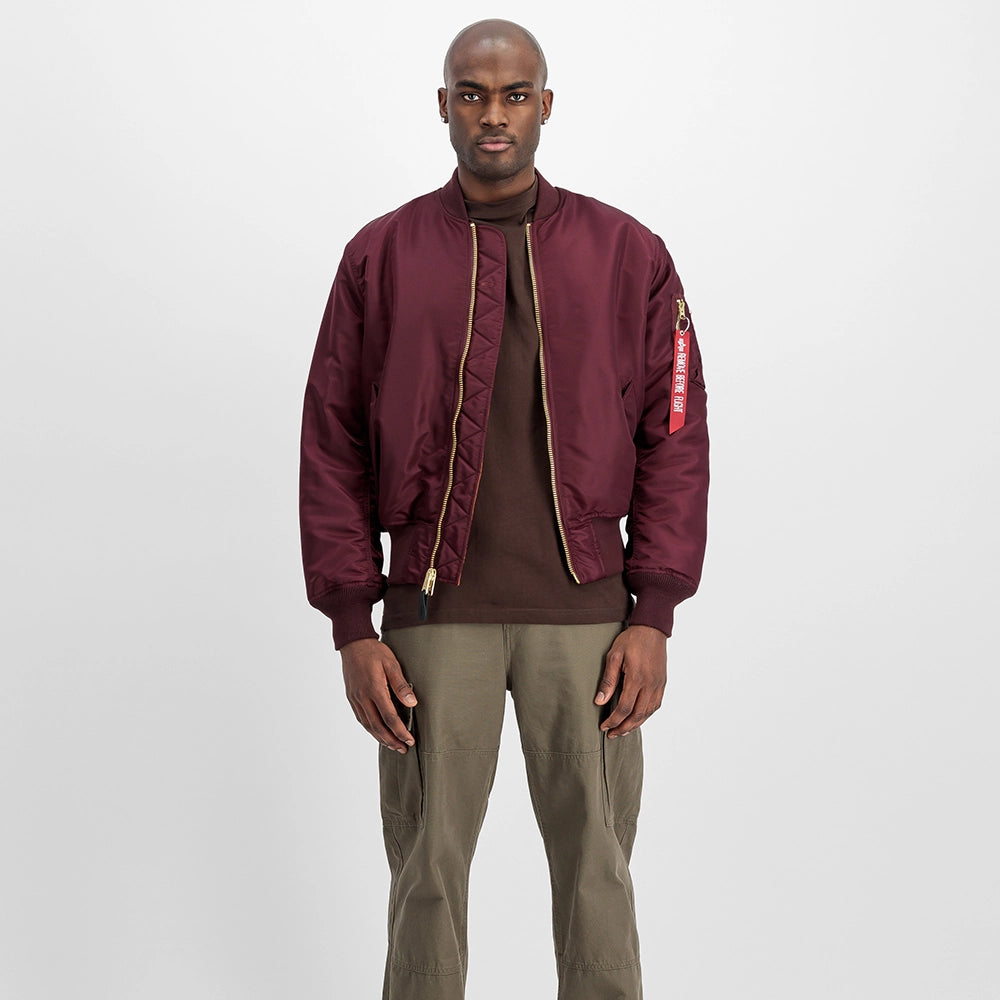 “Alpha Industries MA-1 Bomberjacke in Weinrot. Robuste Jacke aus Flight Nylon, mit orangefarbenem Innenfutter und Utility-Pocket am Ärmel bei Stickabush.“