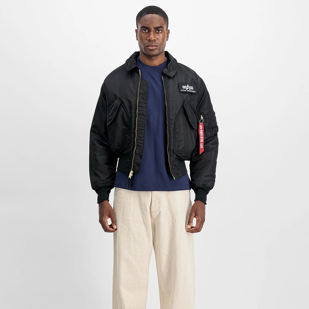 “Schwarze Alpha Industries CWU 45 (HERITAGE) Bomberjacke aus robustem Nylon mit Rippstrickbündchen und Ärmeltasche bei Stickabush Berlin.“