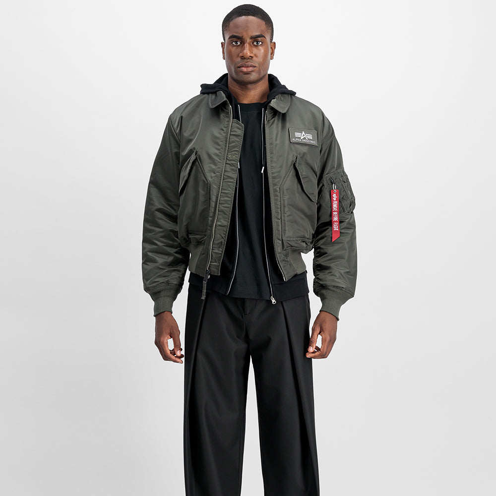 "Alpha Industries CWU 45 (HERITAGE) Bomberjacke in Rep. Grey, aus robustem Nylon, mit Rippbündchen, Reißverschluss und ikonischem Logo-Patch."