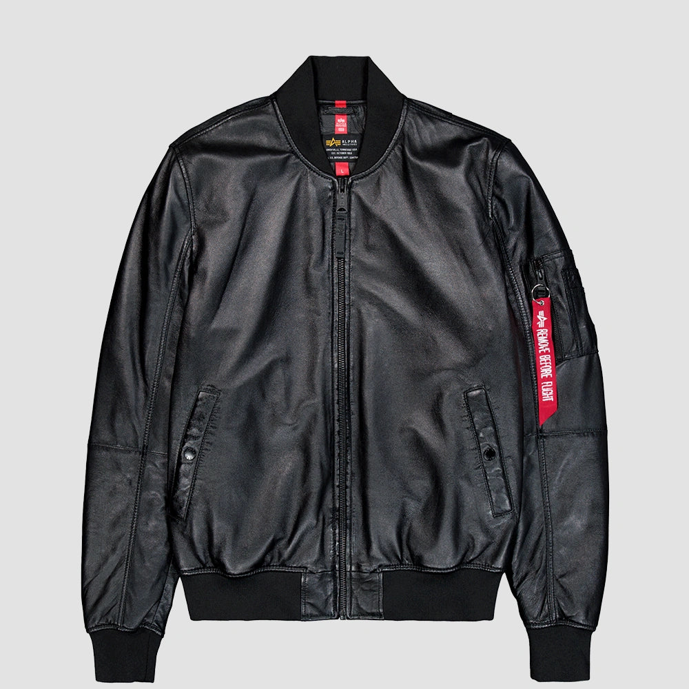 „Schwarze Alpha Industries MA-1 Lederjacke mit Strickkragen, Utility Pocket am Ärmel und rotem Remove Before Flight Tag vor neutralem Hintergrund bei Stickabush Berlin.“