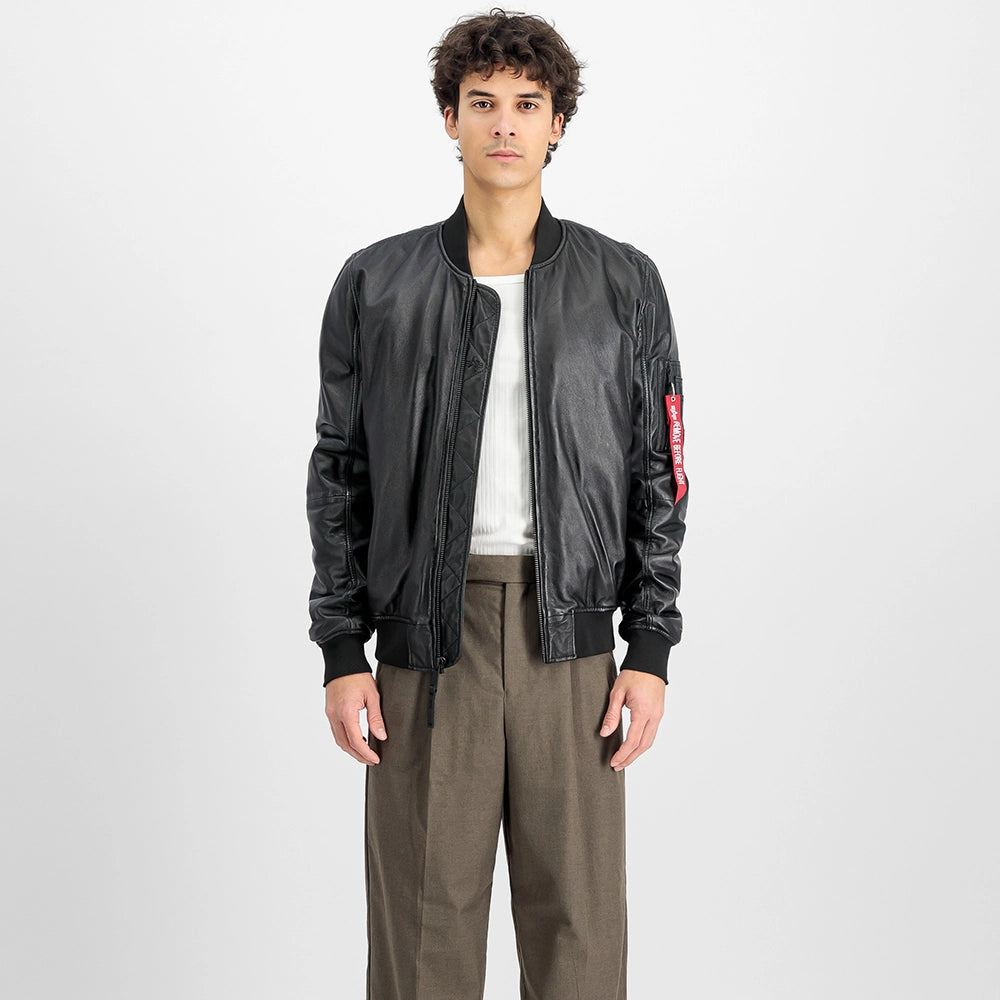 „Schwarze Alpha Industries MA-1 Lederjacke mit Strickkragen, Utility Pocket am Ärmel und rotem Remove Before Flight Tag vor neutralem Hintergrund bei Stickabush Berlin.“