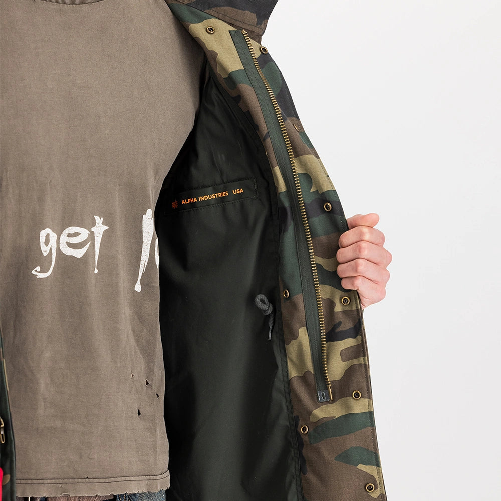 "Camouflage-Feldjacke aus Baumwoll-Mischung von Alpha Industries. Mit vier Pattentaschen, verdeckter Kapuze und Logo-Print auf dem Rücken.“