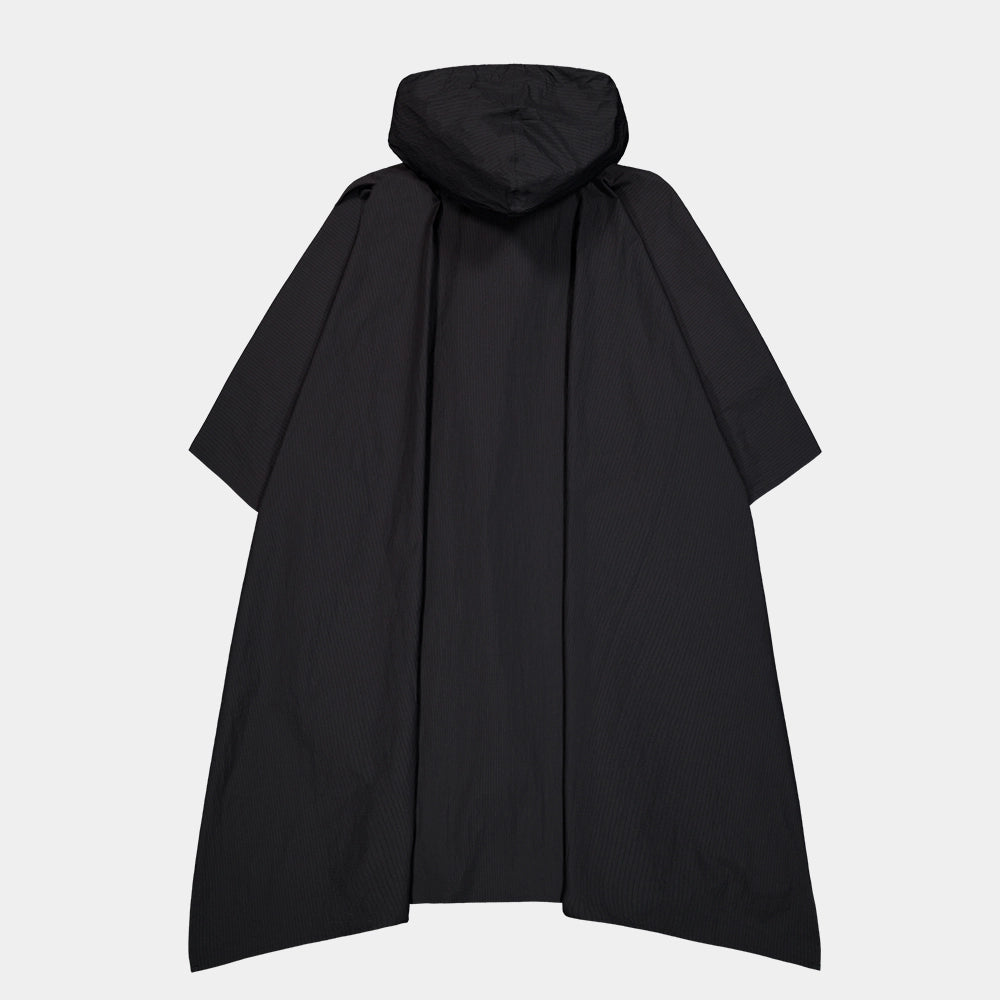 “Schwarzes Alpha Industries Packable Rain Cape mit Logo auf der Brust, verstellbarer Kapuze und rotem Remove Before Flight Anhänger bei Stickabush Berlin.“