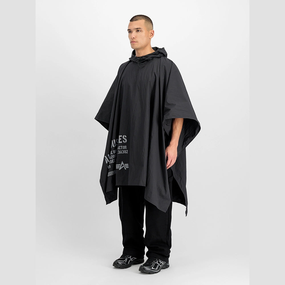 “Schwarzes Alpha Industries Packable Rain Cape mit Logo auf der Brust, verstellbarer Kapuze und rotem Remove Before Flight Anhänger bei Stickabush Berlin.“