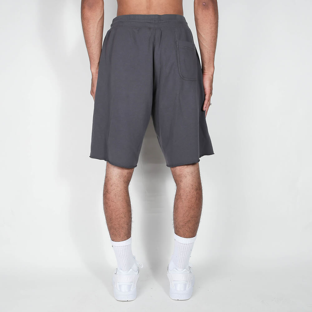 „Nike Sportswear Club Alumni Shorts in Grau/Schwarz mit ungesäumten Kanten, weißem Nike Track & Field Logo-Print und elastischem Bund bei Stickabush Berlin.“