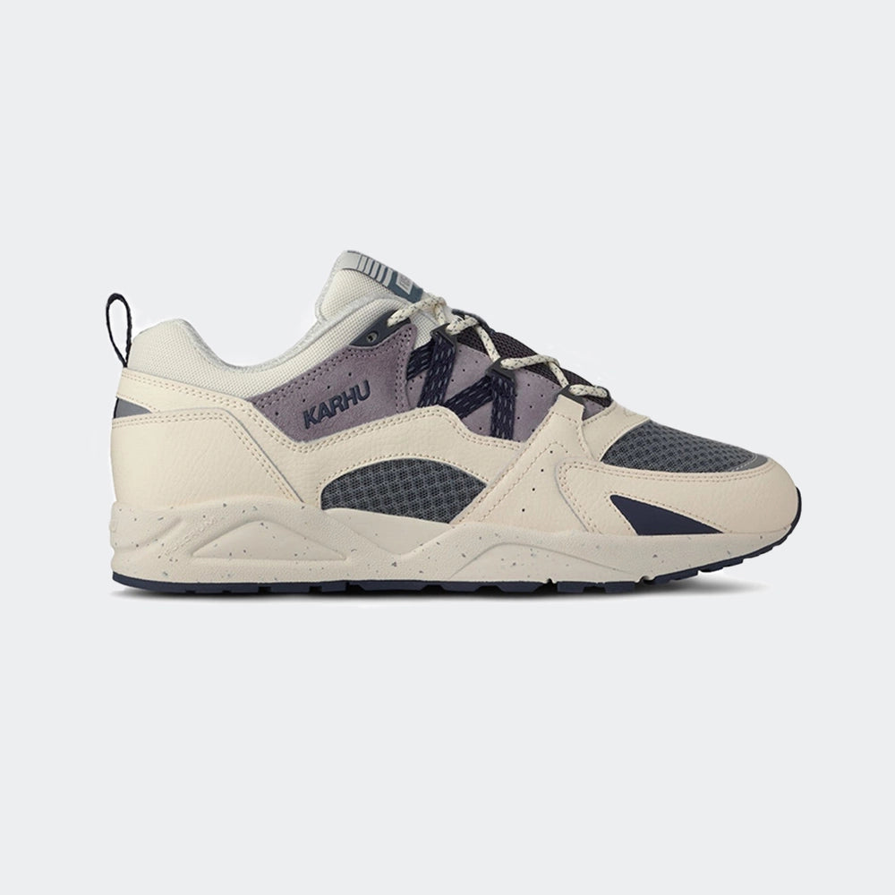 „Der Karhu Fusion 2.0 Herren Sneaker in Beige/Blaugrau/Lila (Naval Academy / Solitary Star) mit reflektierenden Details und praktischer Zuglasche und einer beigen Sohle bei Stickabush Berlin.“