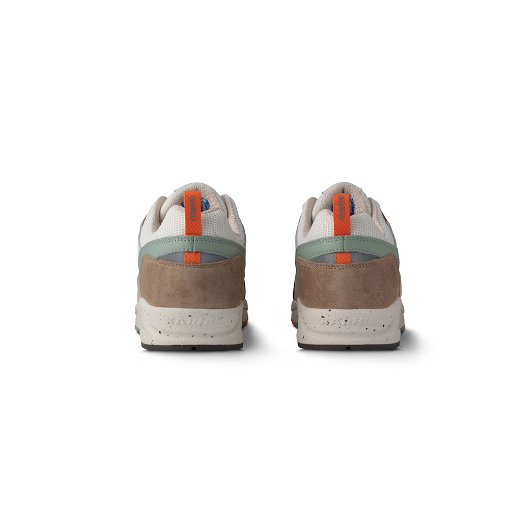 "Wildleder-Sneaker in warmen Braun- und Orangetönen mit beigem Mesh und dem Karhu 'M'-Logo.“