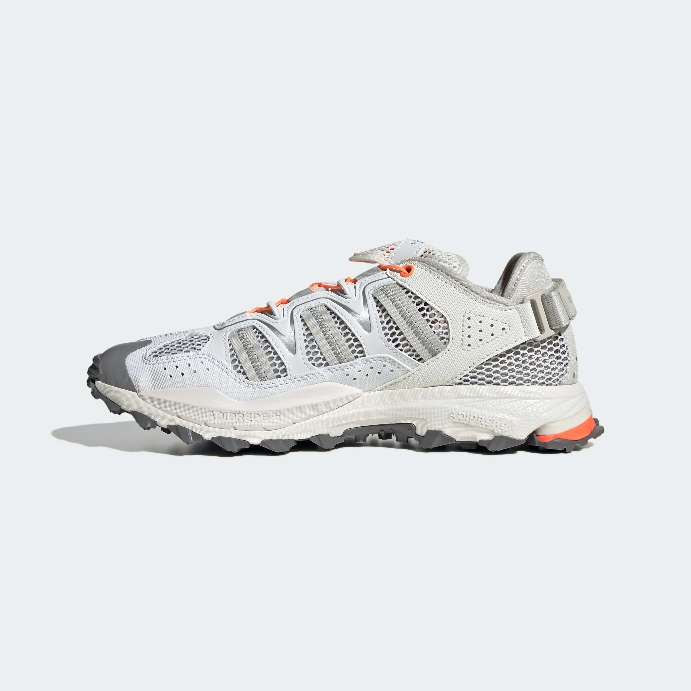 “Weiße ("Footwear White") Adidas Hyperturf Sneaker mit grauen und orangefarbenen Akzenten. Trail-inspirierte Schuhe aus Textil und Synthetik-Wildleder, mit Adiprene+-Dämpfung und markanter Außensohle.“