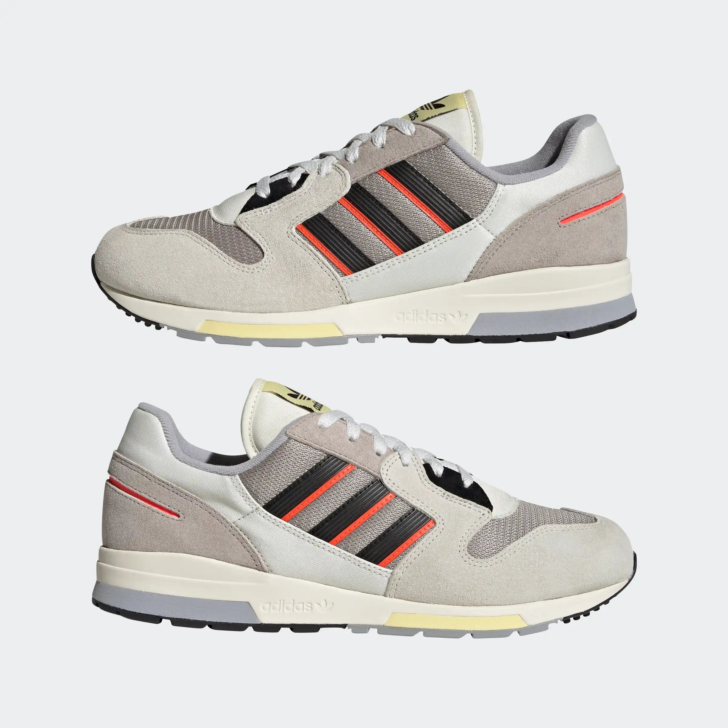 Graue Adidas ZX 420 Sneaker mit metallgrauen, orangenen und schwarzen Akzenten. Retro-Laufschuhdesign mit Wildleder- und Mesh-Details, sichtbare Dämpfungselemente in der Sohle."