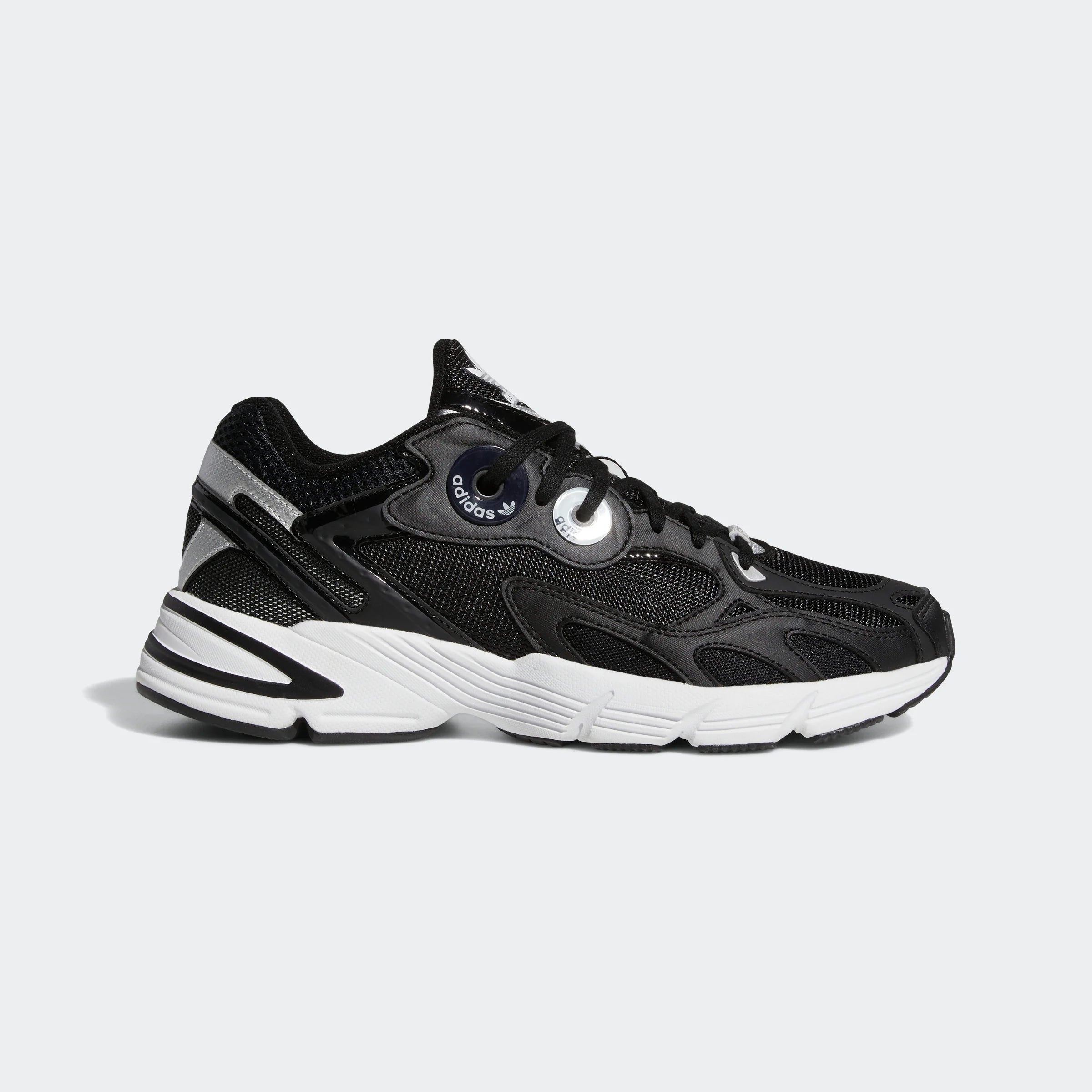 “Schwarzer Adidas Astir W Sneaker mit weißen Akzenten. Damenschuh aus atmungsaktivem Mesh und Synthetik mit übergroßen Ösen, leichter EVA-Zwischensohle und auffälliger Außensohle.“