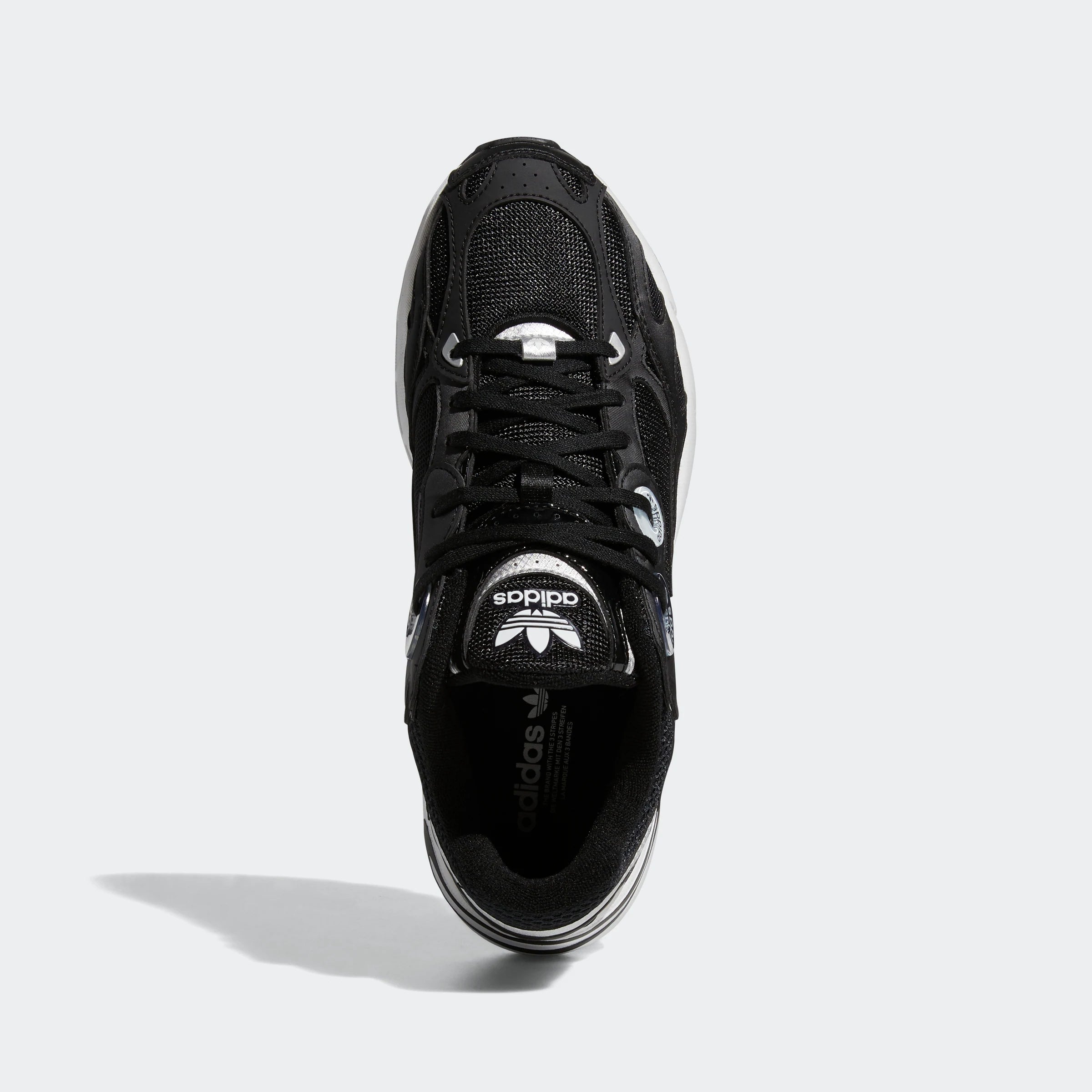 “Schwarzer Adidas Astir W Sneaker mit weißen Akzenten. Damenschuh aus atmungsaktivem Mesh und Synthetik mit übergroßen Ösen, leichter EVA-Zwischensohle und auffälliger Außensohle.“