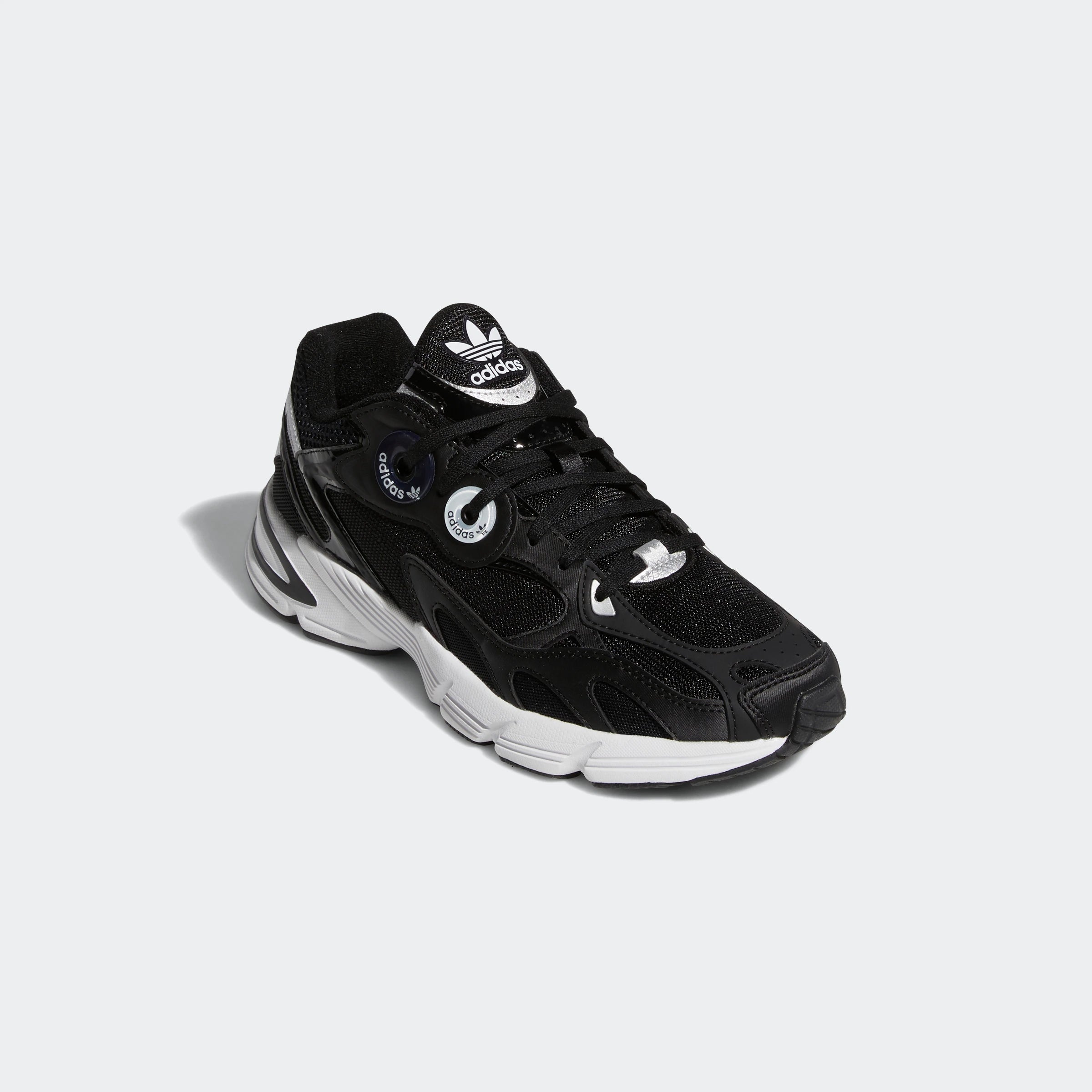 “Schwarzer Adidas Astir W Sneaker mit weißen Akzenten. Damenschuh aus atmungsaktivem Mesh und Synthetik mit übergroßen Ösen, leichter EVA-Zwischensohle und auffälliger Außensohle.“