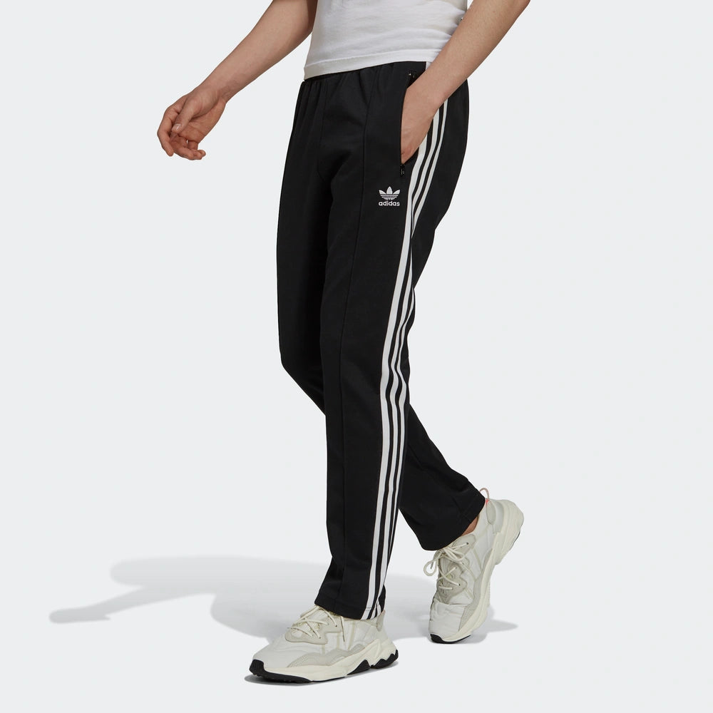 "Adidas Classics Beckenbauer Track Pants, Black, glattes Trikotmaterial (vermutlich Polyester), klassische Trainingshose mit drei weißen Streifen und Reißverschlusstaschen."