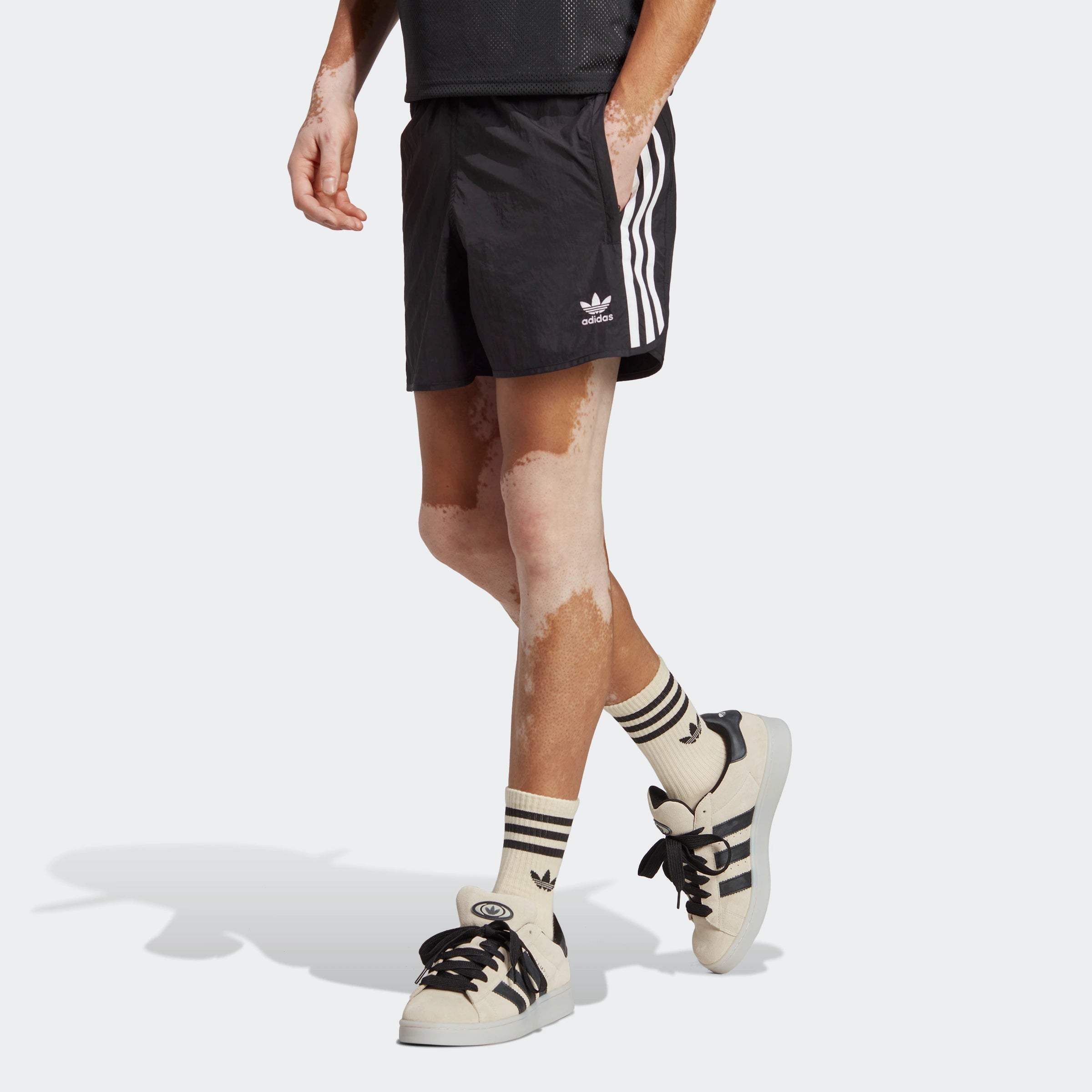 "Schwarze Adidas Sprinter Shorts mit weißen seitlichen Streifen. Kurze, sportliche Hose mit elastischem Bund und kleinem Adidas Logo am Bein."