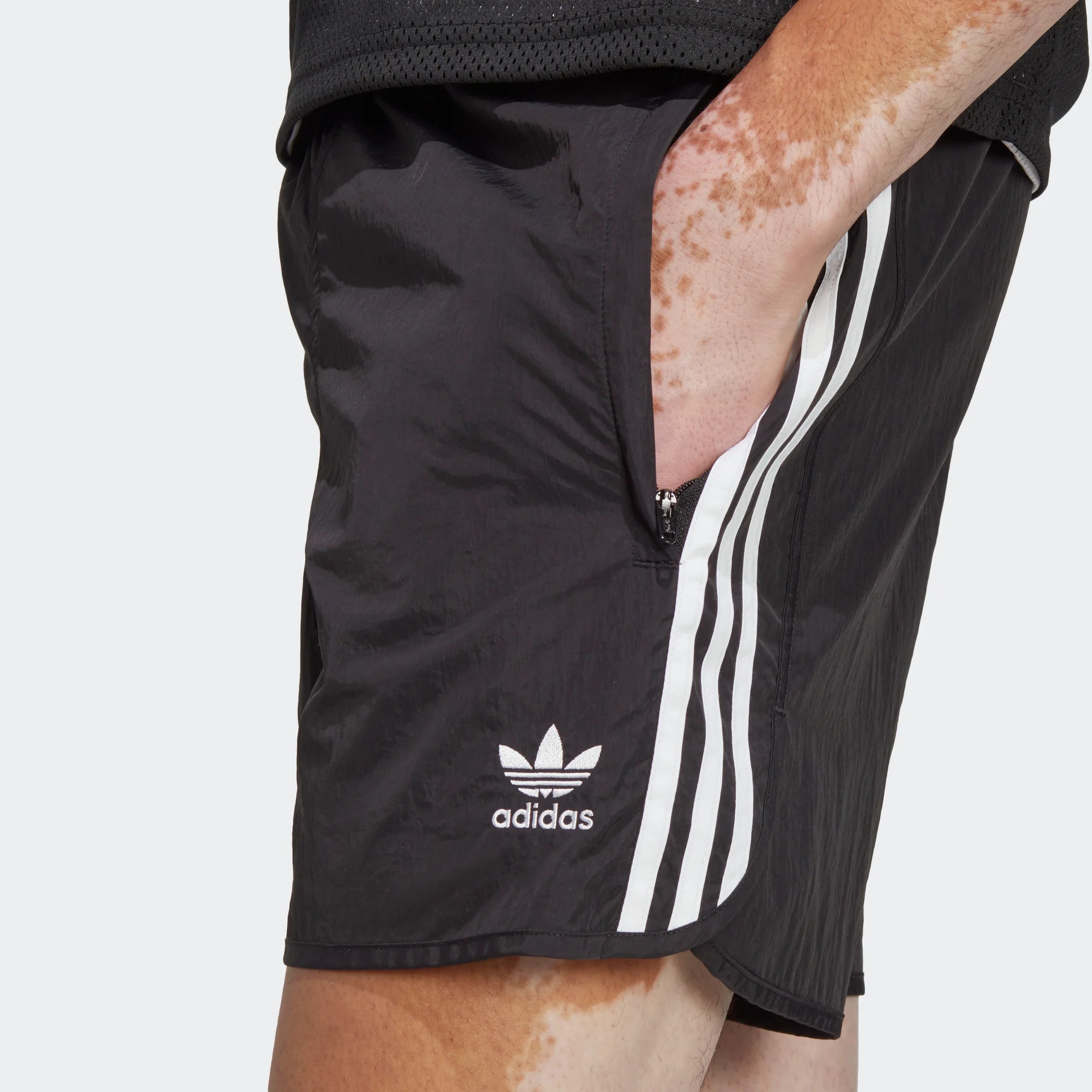 "Schwarze Adidas Sprinter Shorts mit weißen seitlichen Streifen. Kurze, sportliche Hose mit elastischem Bund und kleinem Adidas Logo am Bein."