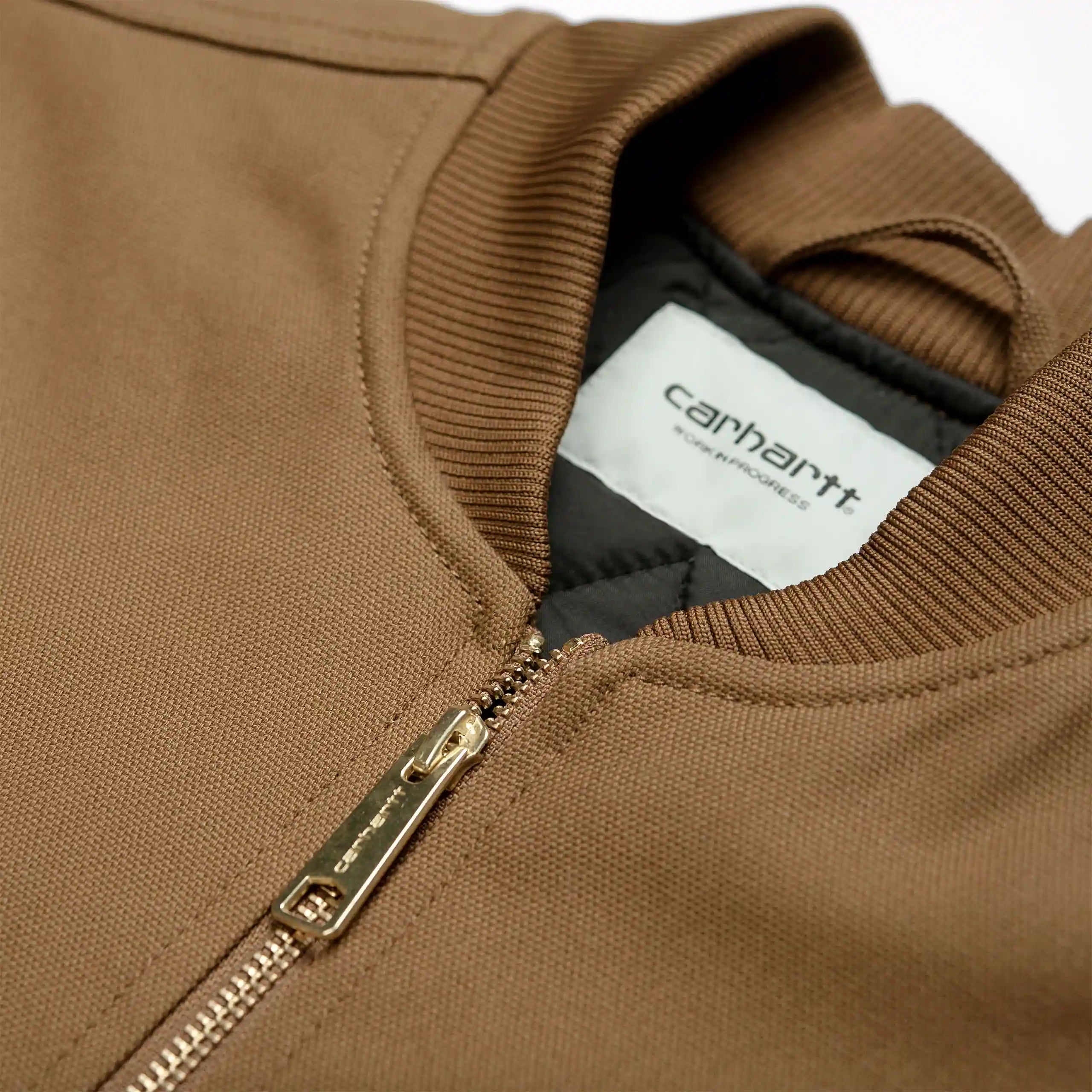 "Braune Carhartt WIP Weste aus Canvas mit V-Ausschnitt, Reißverschluss und Logo-Patch auf der Brust."
