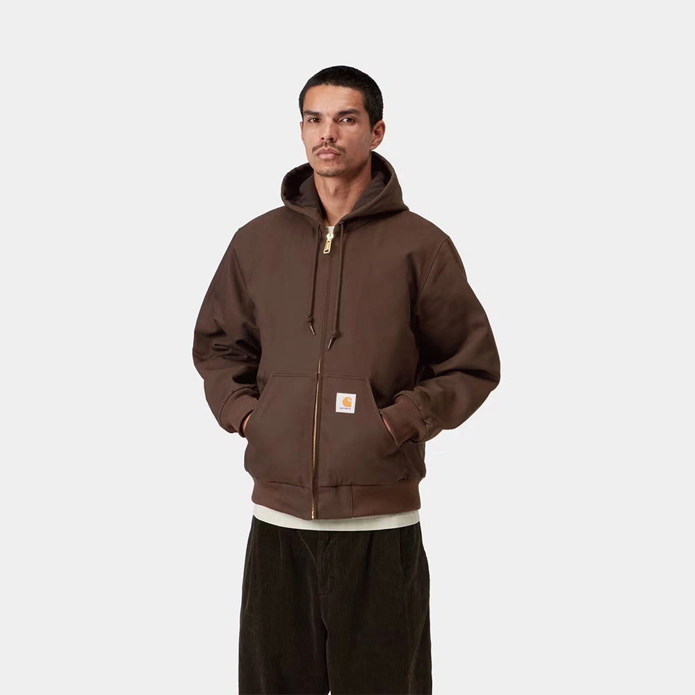 Carhartt WIP Active Jacket Winter in Tobacco – Vorderansicht am Model der braunen Canvas-Winterjacke mit Kapuze und wärmendem Thinsulate-Futter.