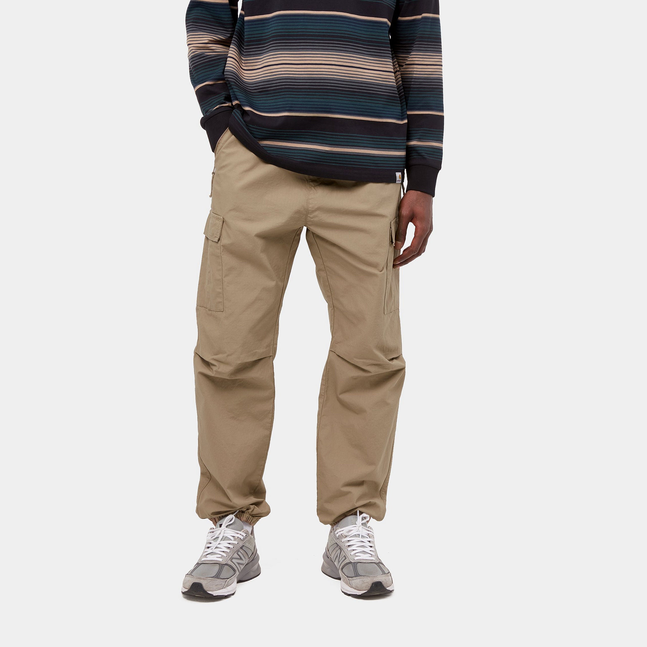 Carhartt WIP Cargo Jogger in Leather (rinsed), robuste braune Baumwollhose mit seitlichen Cargo-Taschen, elastischem Bund und Beinbündchen im Tapered Fit.