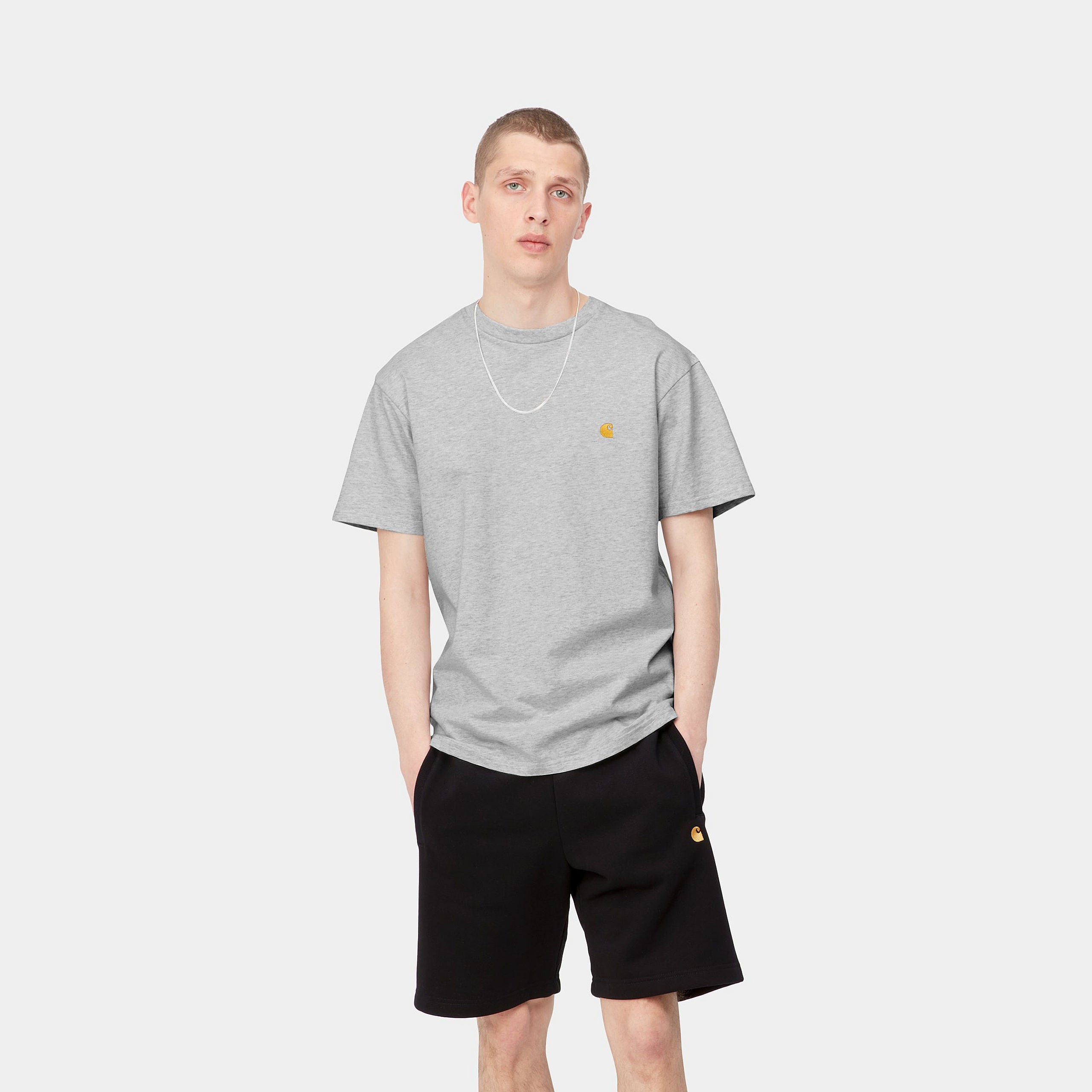 „Grau meliertes Carhartt WIP S/S Chase T-Shirt in Ash Heather / Gold (I026391) mit goldener Logo-Stickerei am Ärmel – zeitloses Heavyweight-Basic bei Stickabush Berlin.“