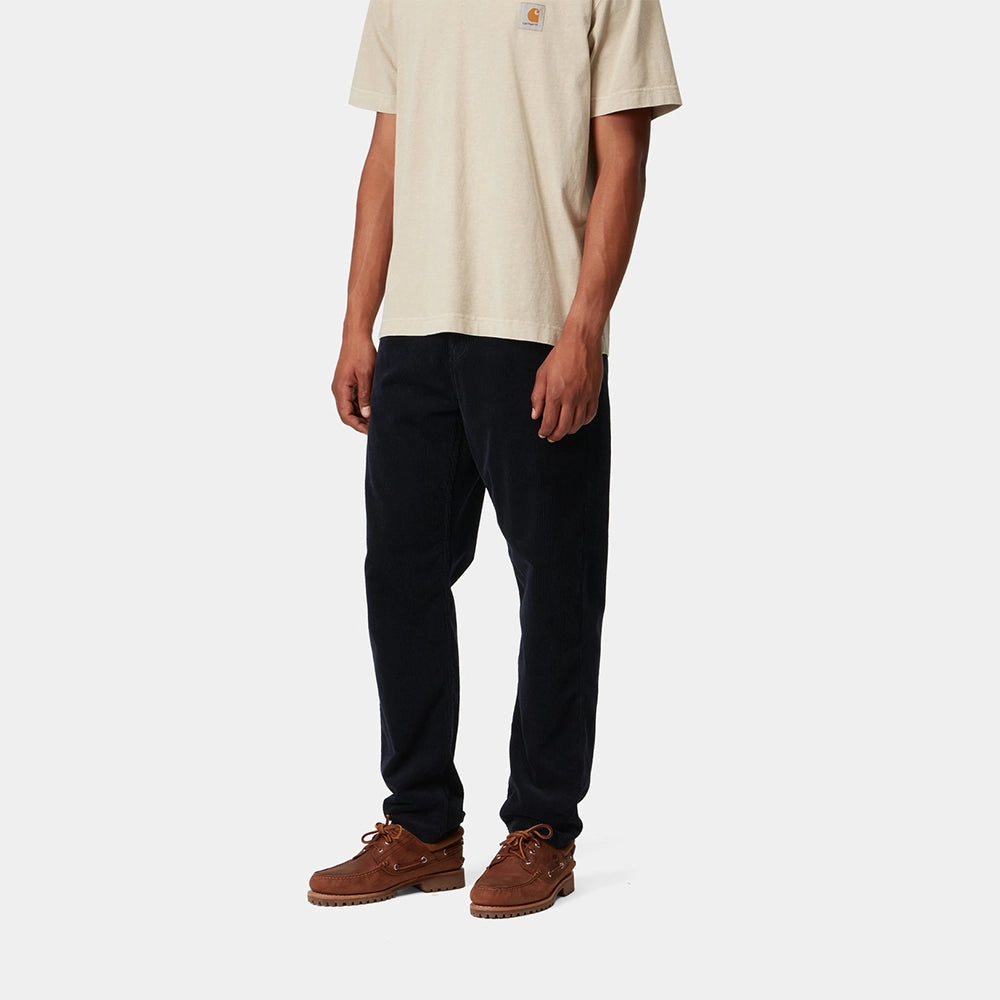 "Carhartt Newel Pant in Dunkelblau (Rinsed), Cordhose aus Baumwolle, lockere Passform, klassische Jeanshose in tiefem Marineblau bei Stickabush Berlin."