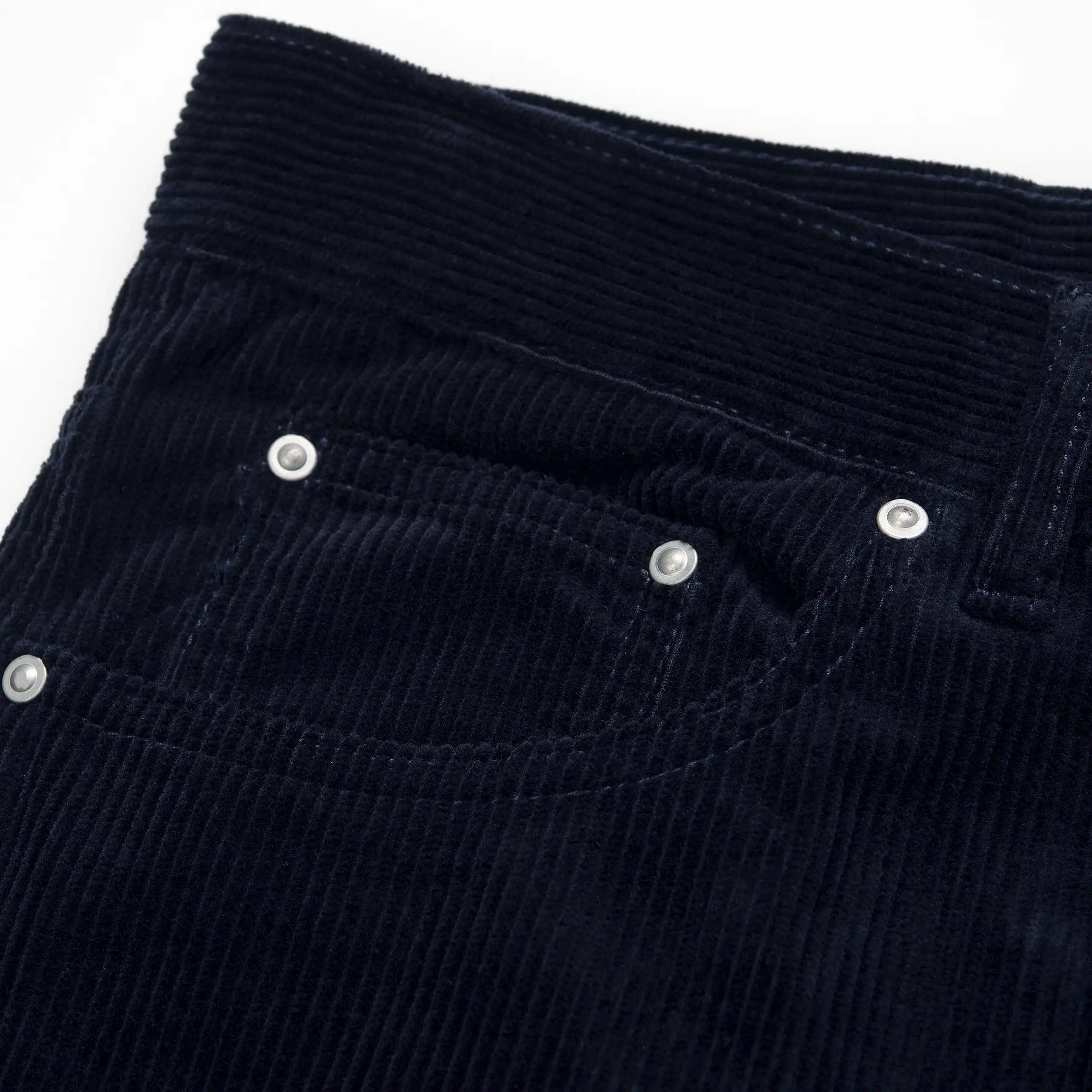 "Carhartt Newel Pant in Dunkelblau (Rinsed), Cordhose aus Baumwolle, lockere Passform, klassische Jeanshose in tiefem Marineblau."