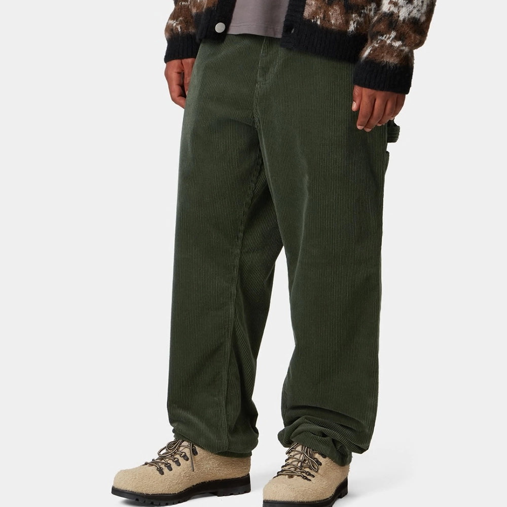 "Grüne Workwear Cordhose von Carhartt WIP im Workwear-Stil, mit geradem Bein, Gesäßtaschen und Werkzeugtaschen am Oberschenkel.“