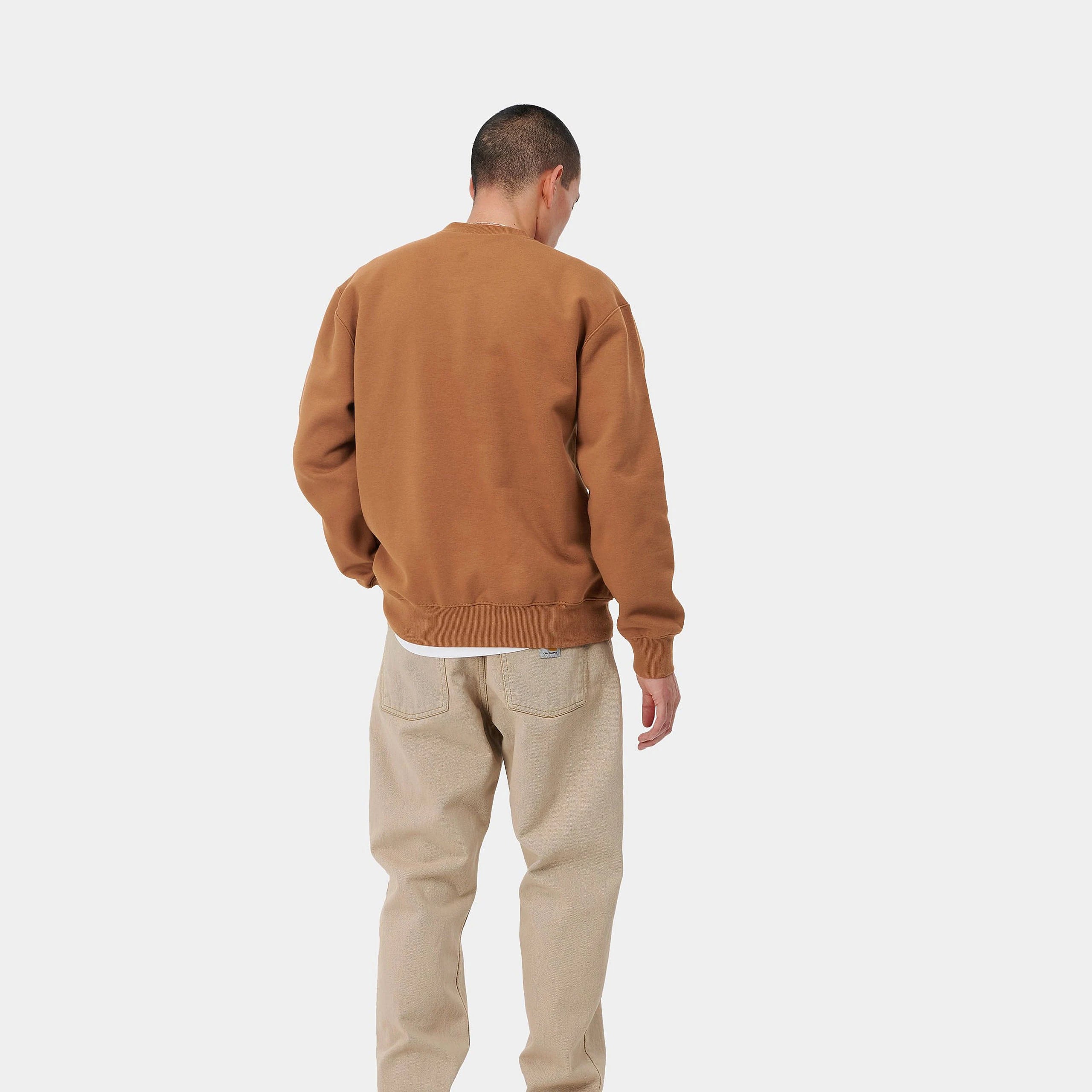 "Carhartt WIP Carhartt Sweat – Rum / Black. Braunes Sweatshirt aus Baumwoll-Jersey, mit lockerem Schnitt und großem schwarzem Carhartt Logo-Print auf der Brust."