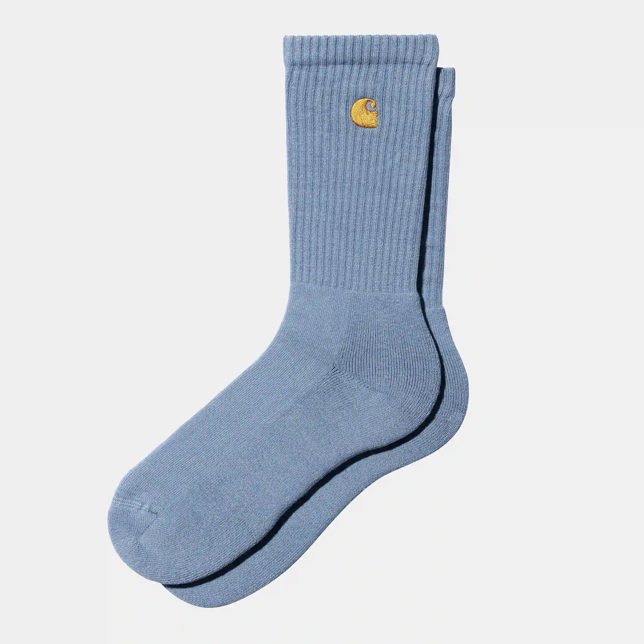 "Carhartt WIP Chase Socks – Charm Blue / Gold. Hellblaue Socken aus Baumwoll-Mix, mit geripptem Schaft und gesticktem, goldenem Carhartt WIP Logo am Knöchel."