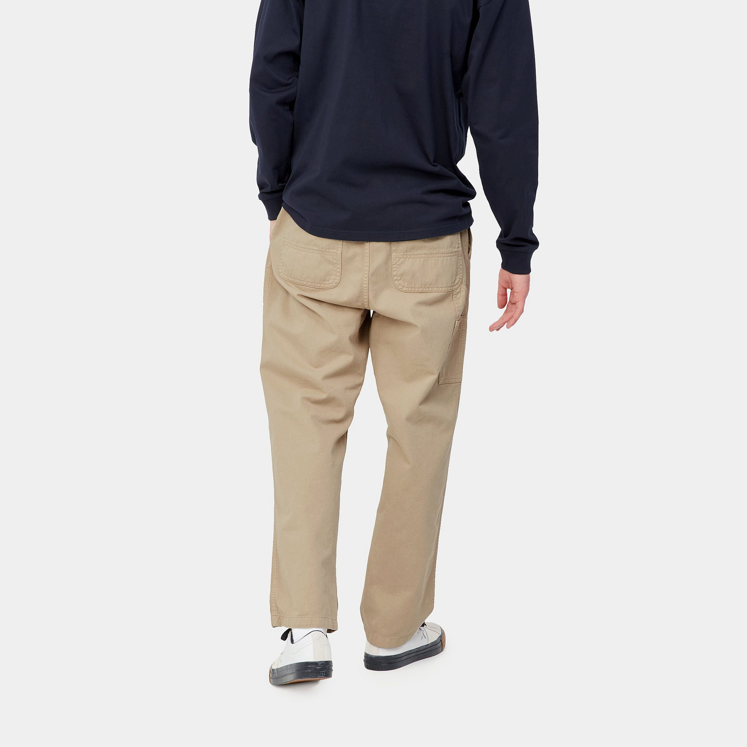 "Carhartt WIP Flint Pant – Wall (garment dyed). Beigefarbene Stoffhose aus Baumwoll-Cord, mit lockerer Passform und Carhartt WIP Square Label am Gesäß."