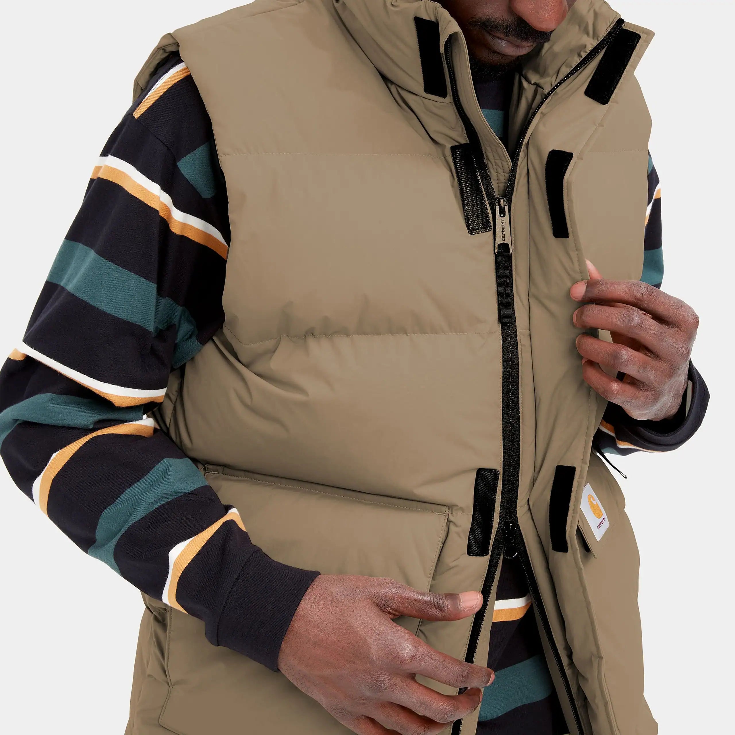 "Carhartt WIP Milton Vest – Tanami. Braune, gepolsterte Steppweste aus wasserabweisendem Nylon-Twill, mit Stehkragen, Reißverschluss, Taschen und gewebtem Logo."