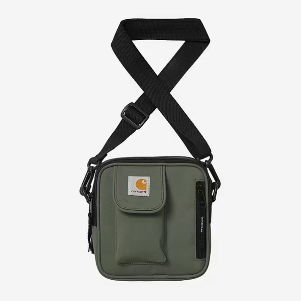 Carhartt WIP Essentials Bag, Small – Opuntia. Grüne Umhängetasche aus Polyester-Duck-Canvas, mit verstellbarem Schultergurt, Reißverschlüssen und Carhartt WIP Logo auf der Vorderseite.