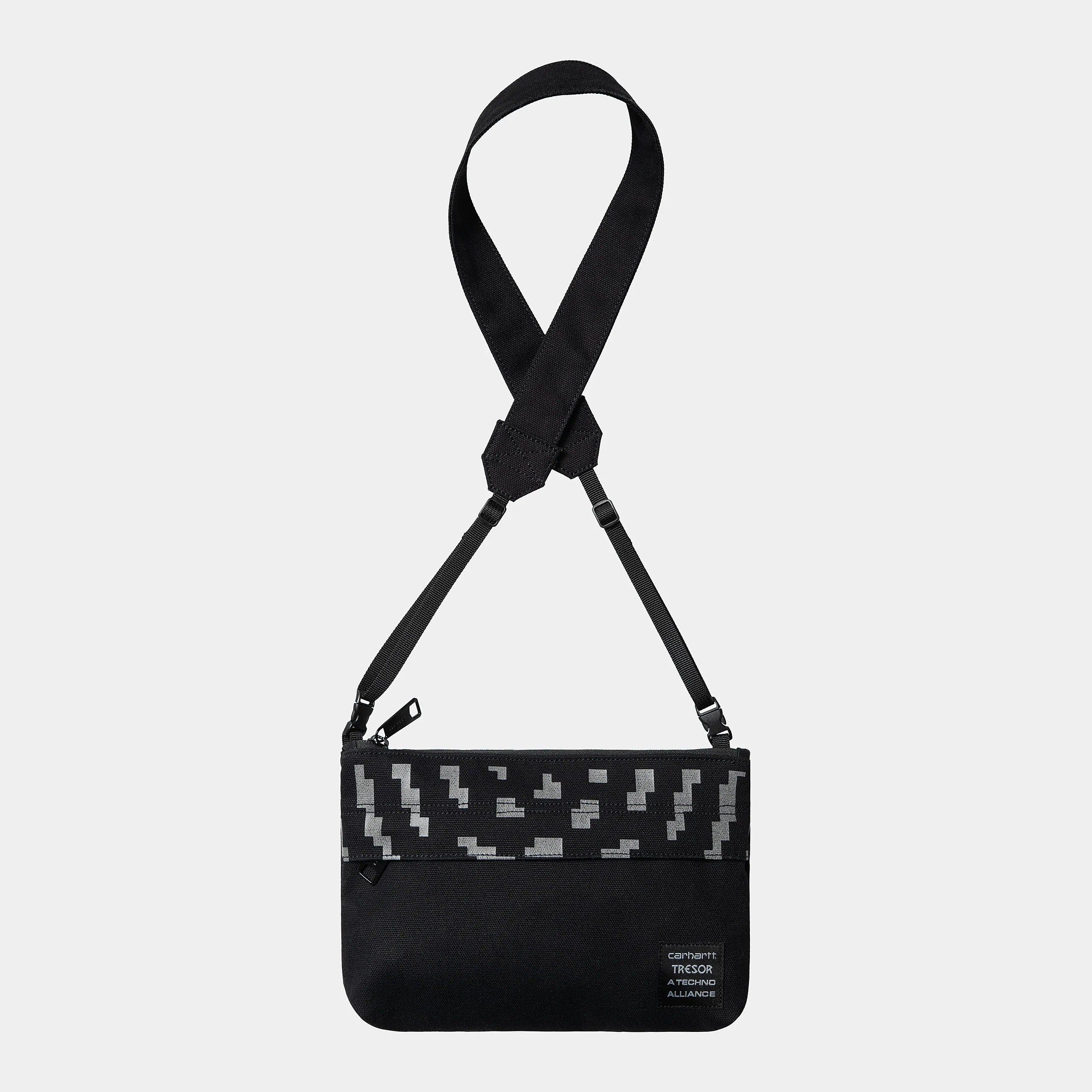 "Carhartt WIP x TRESOR Way Of The Light Strap Bag, Schwarz/Dunkelgrau reflektierend, kleine Umhängetasche mit reflektierenden Details und Logos."