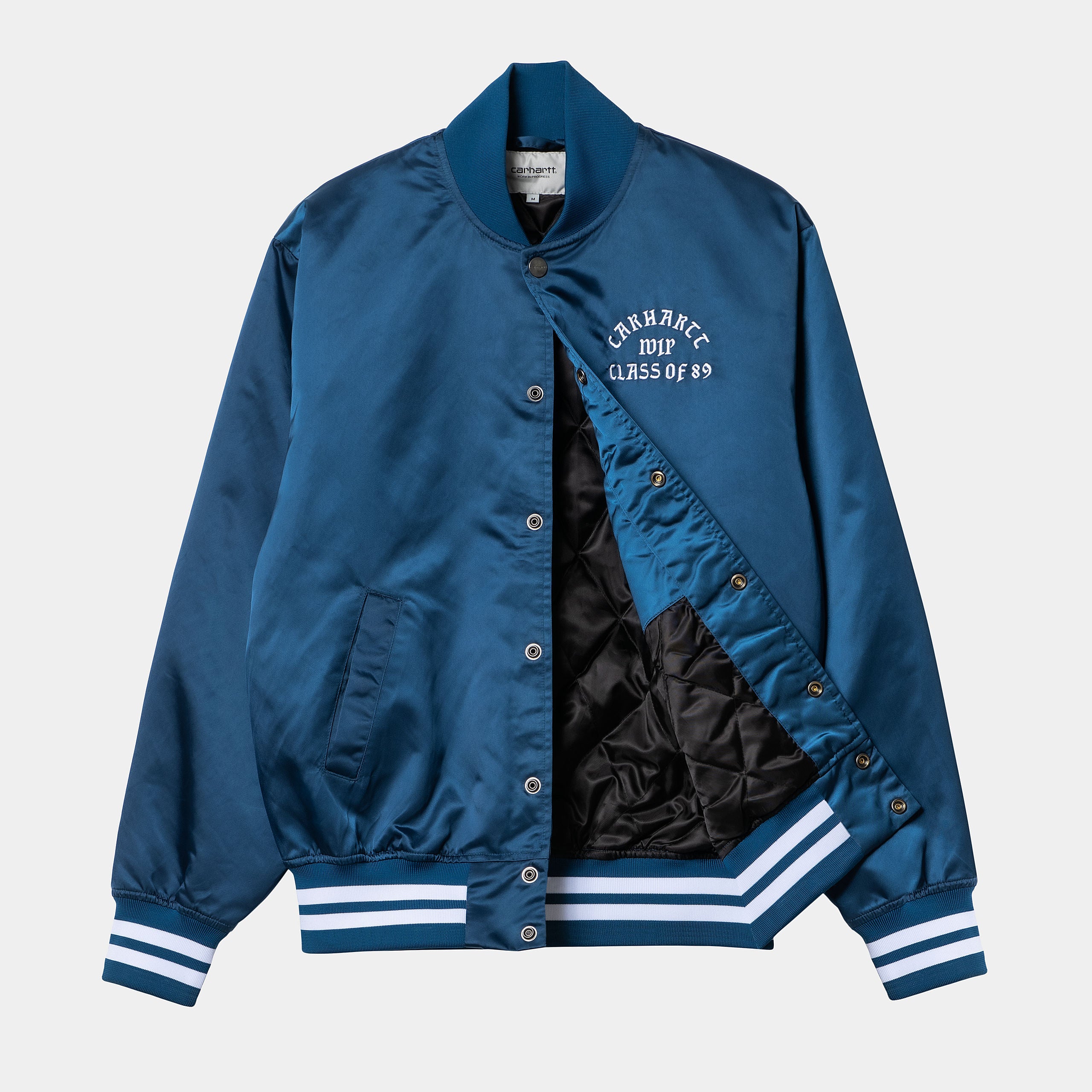 "Carhartt WIP Class of 89 Bomber Jacke in Elder Weiß Vorderansicht mit Logo-Stickerei und schwarzem Lining bei Stickabush Berlin.“