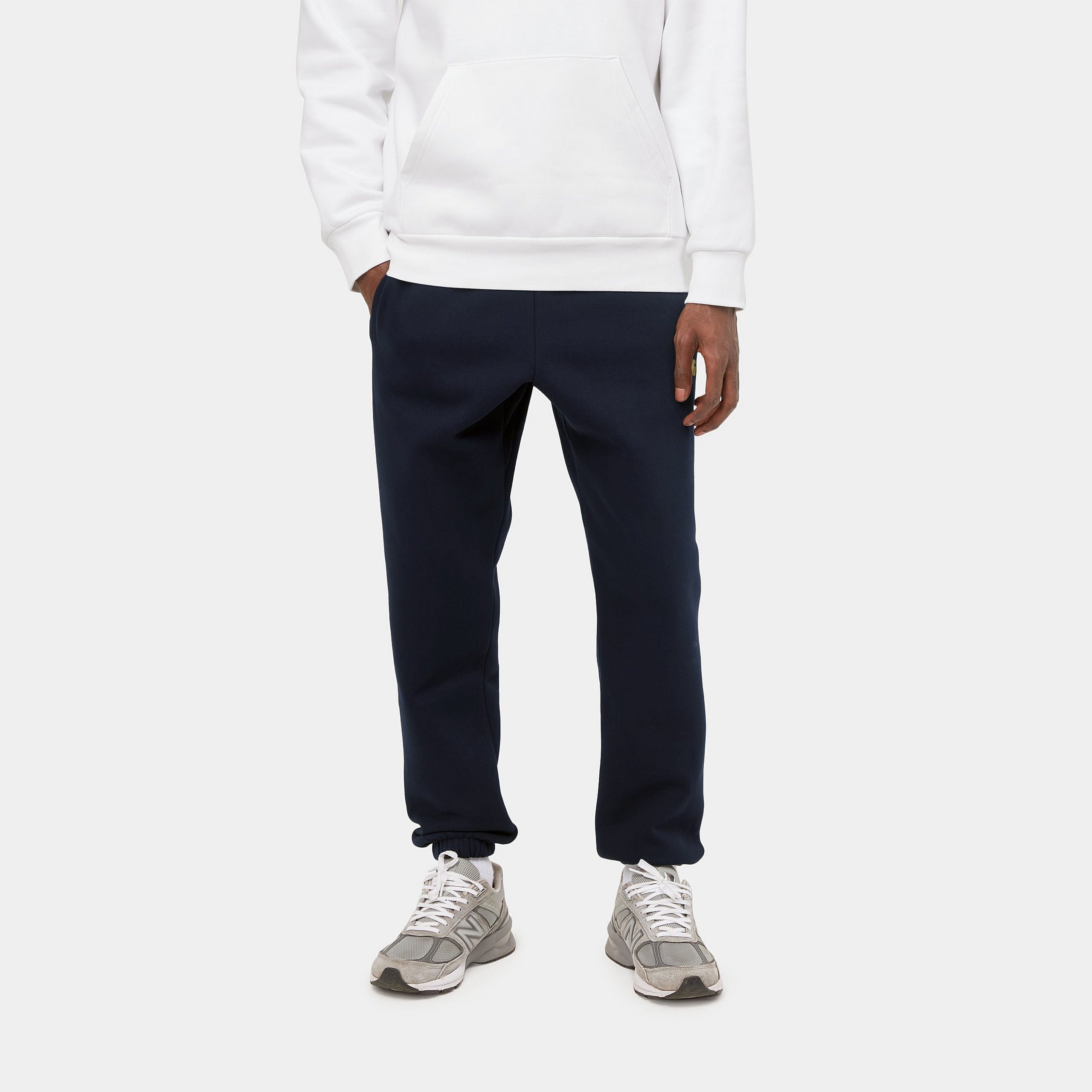 "Carhartt Chase Sweat Pant in Dunkelblau/Gold, Baumwollmischung, elastischer Bund, goldene Logo-Stickerei."