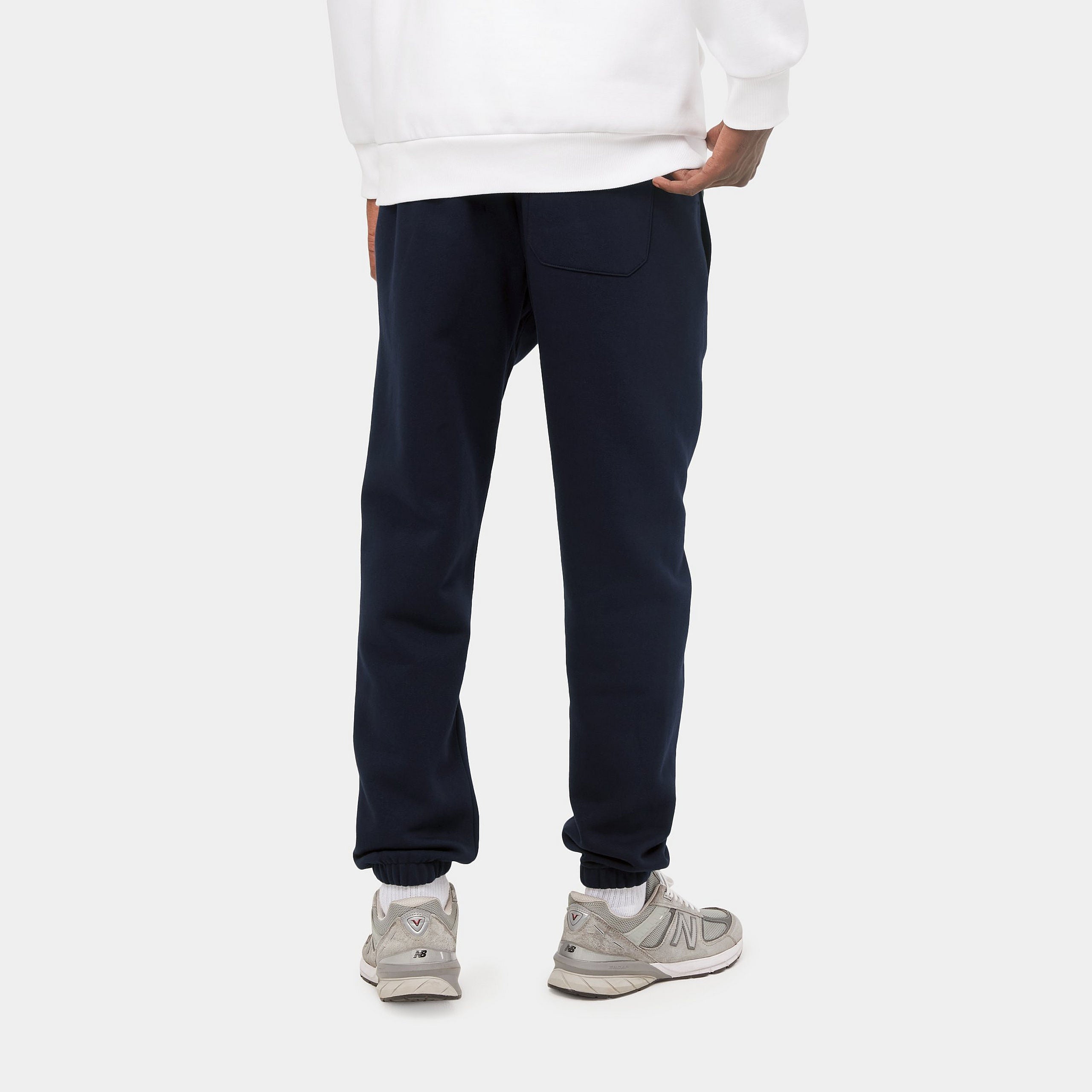 "Carhartt Chase Sweat Pant in Dunkelblau/Gold, Baumwollmischung, elastischer Bund, goldene Logo-Stickerei."