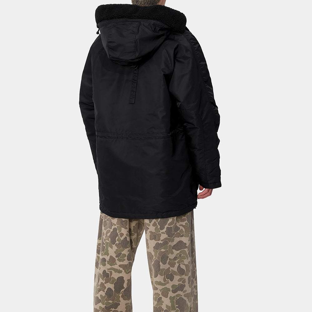 Carhartt WIP Hooded Olten Parka in Schwarz, getragen von einem Model, mit Kapuze und langen Ärmeln, aus robustem Canvas-Material.