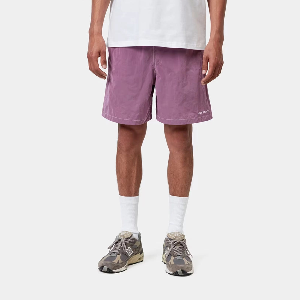 “Carhartt WIP Canby Swim Trunks in Gentle Purple Lila mit weißem Logo-Schriftzug, lässige Badehose mit Mesh-Innentasche bei Stickabush Berlin.“