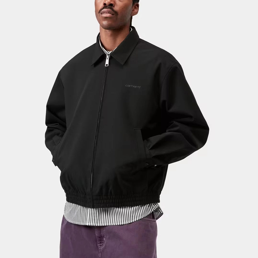 "Carhartt WIP Neven Jacket in Black/Graphite mit sichtbarem Square-Label auf der Brusttasche und technischem Reißverschluss bei Stickabush Berlin."