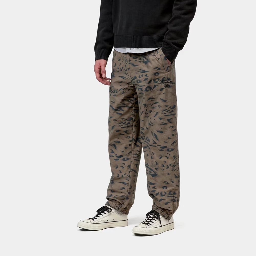 Carhartt WIP Travon Pant in Duck Feather Print Cypress / Black – Vorderansicht am Model der wasserabweisenden Hose mit Entenfeder-Muster und Stickereien.