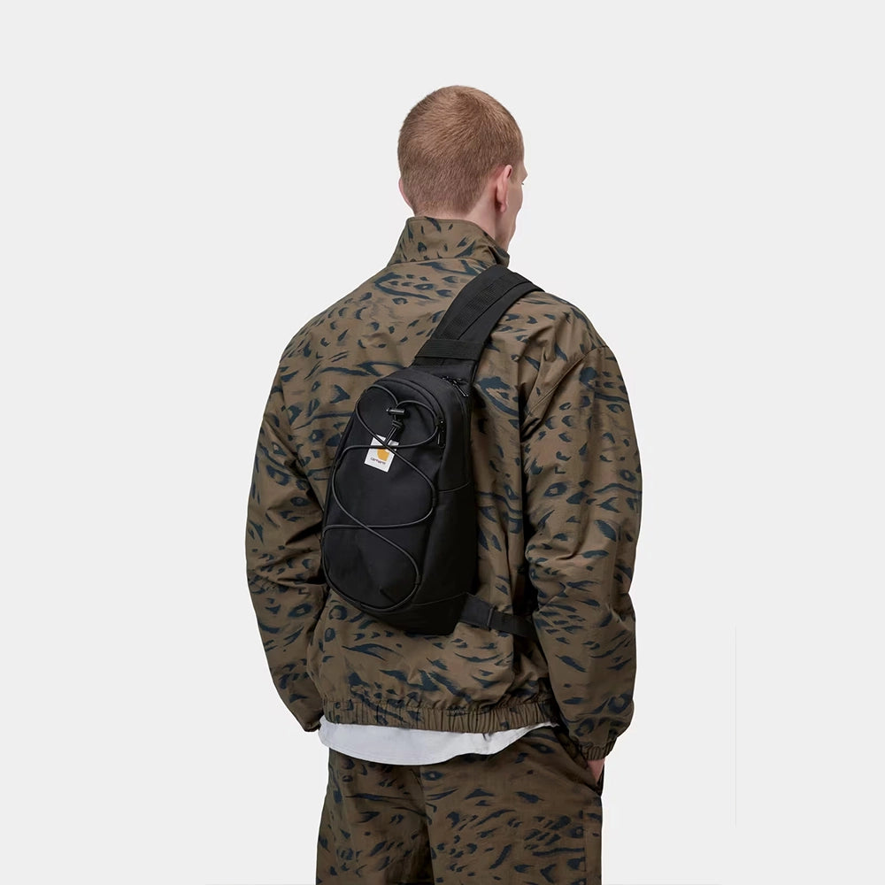 “Carhartt WIP Kyle Sling Bag in Schwarz, funktionale Crossbody-Tasche mit verstellbarem Riemen und quadratischem Logo-Label bei Stickabush Berlin.“