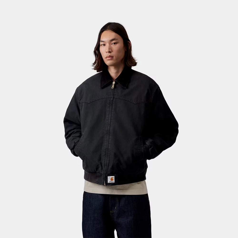 Carhartt WIP OG Santa Fe Jacket in Black / Black – Vorderansicht am Model der schwarzen Stone-Canvas-Workwear-Jacke mit farblich abgesetzten Cord-Details und Reißverschlusstasche.