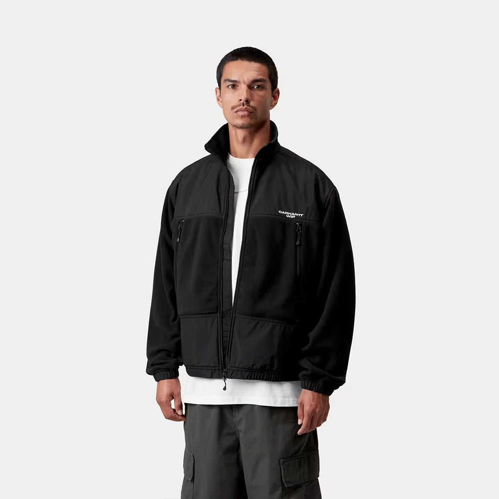 Carhartt WIP Edmore Jacket in Black / White – Vorderansicht Outfit am Model der schwarz-weißen Jacke mit Reißverschlusstaschen und grafischer Stickerei.