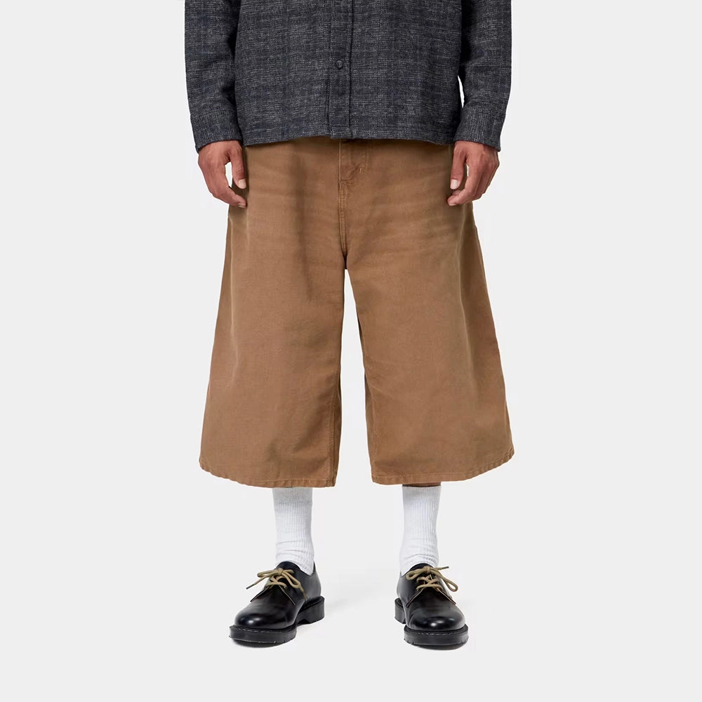 Carhartt WIP OG Single Knee Long Short in WIP H Brown – Vorderansicht Outfit am Model der braunen Canvas-Workwear-Shorts mit Tool-Taschen und Hammerlasche.