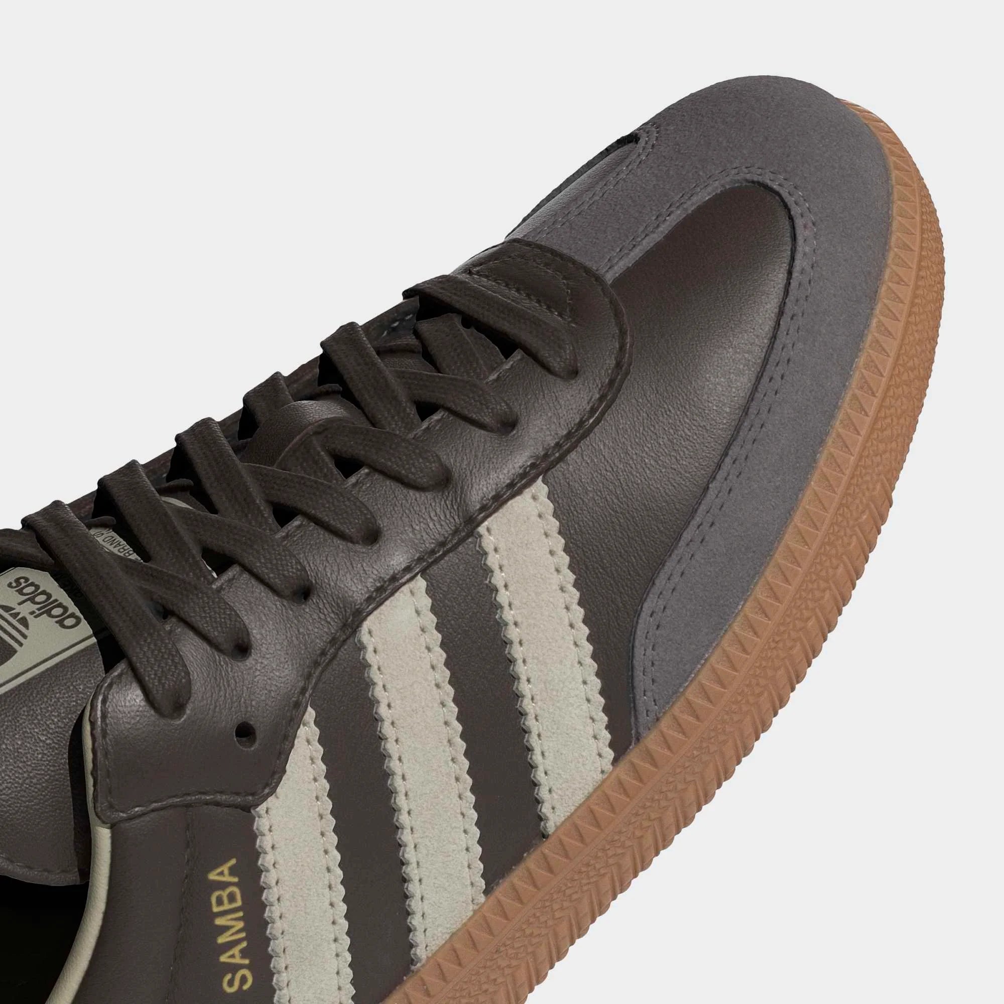 “Detailansicht des adidas Originals Samba OG in Braunem Leder mit Putty Grey Wildleder-Kappe und goldenem Branding bei Stickabush Berlin.“